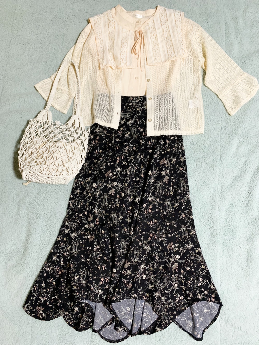 ブラック系のパンプス、ブラック系のスカート、ホワイト系のハンドバッグを着用したレディースの夏コーディネートの3枚目の写真