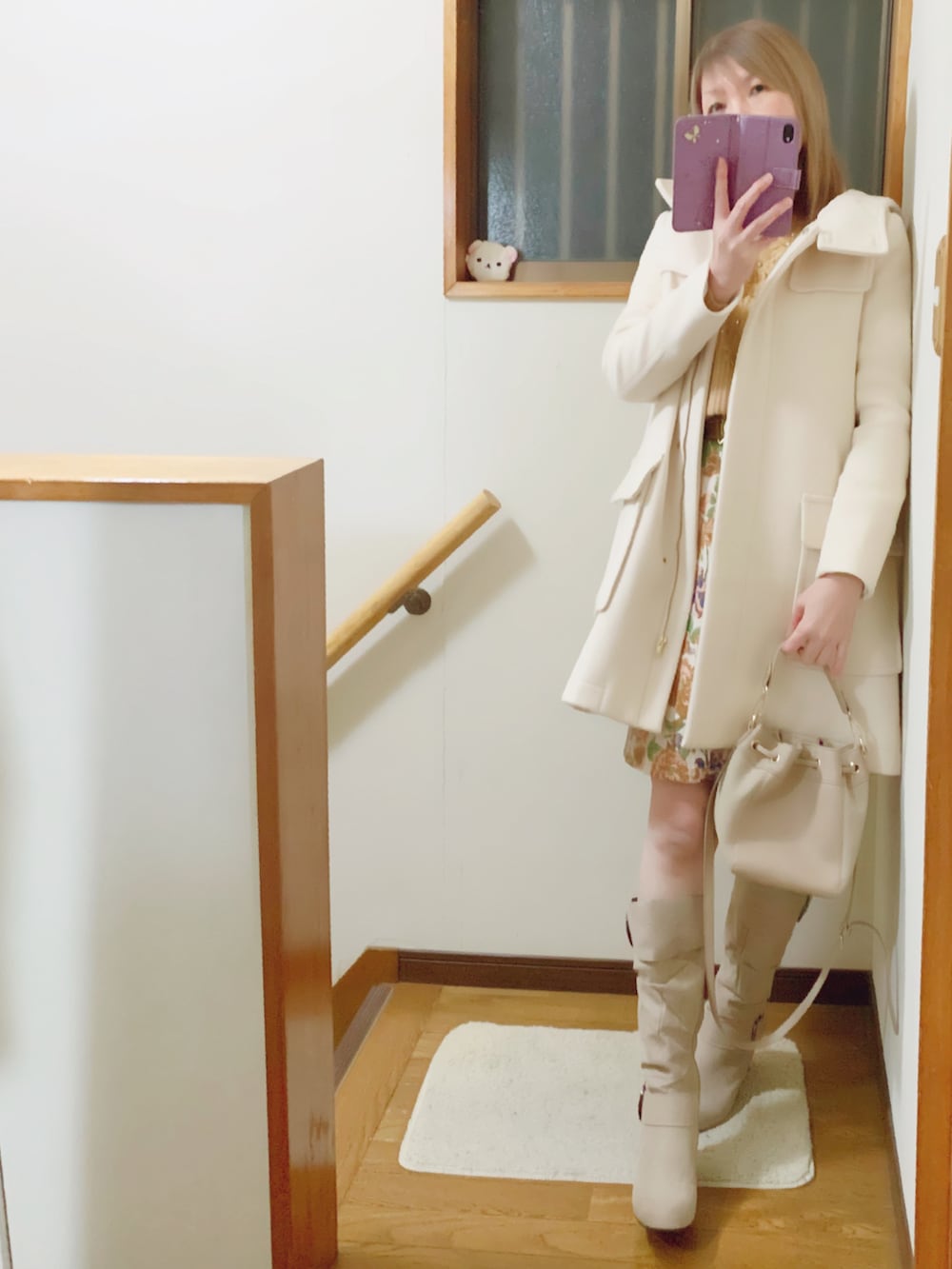 ベージュ系のニット/セーター、ベージュ系のショルダーバッグ、ホワイト系のジャケット/アウターを着用したレディースの冬コーディネートの4枚目の写真