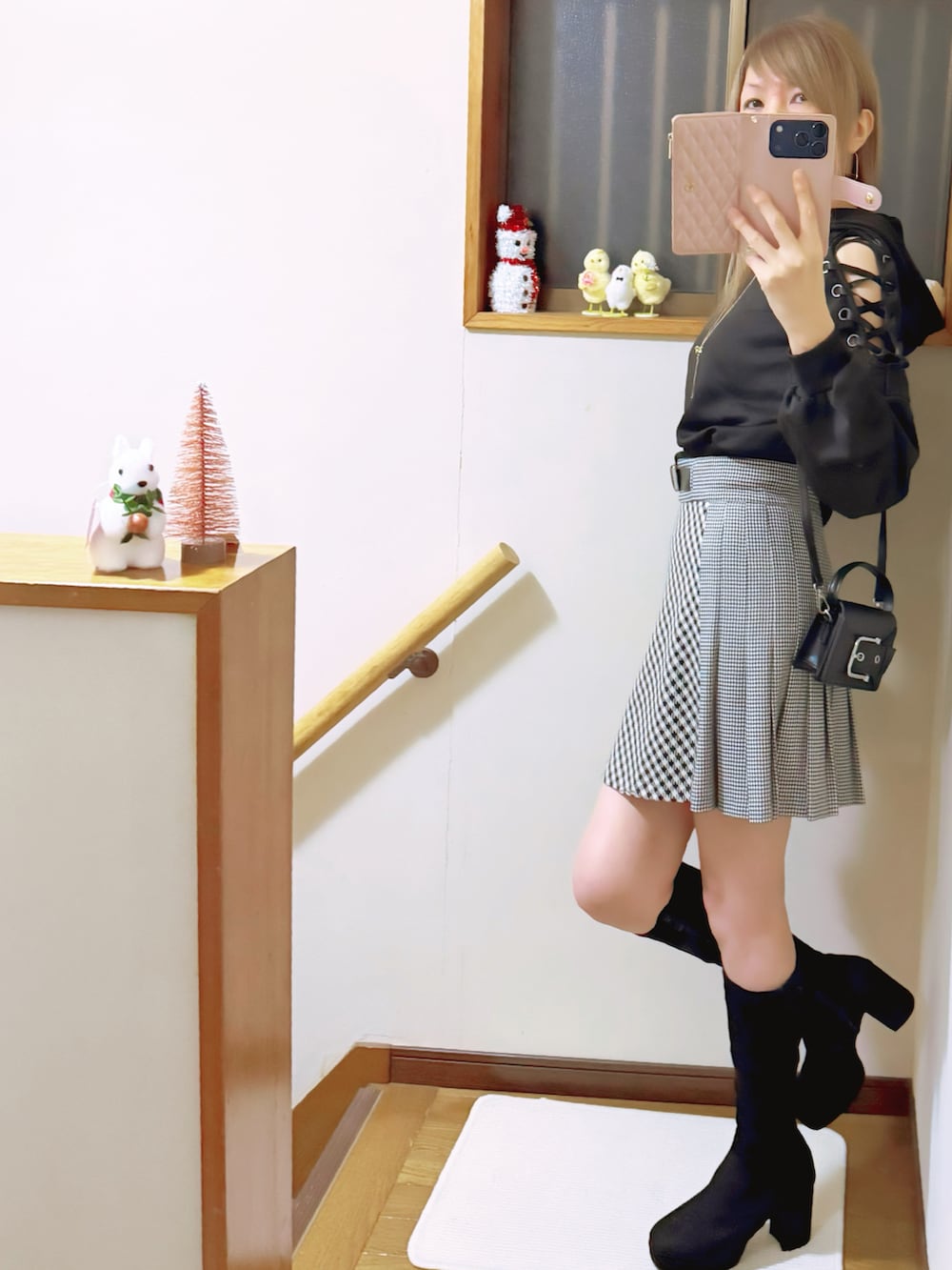 ブラック系のブーツ、ブラック系のパーカー、ブラック系のスカートを着用したレディースの秋コーディネートの3枚目の写真