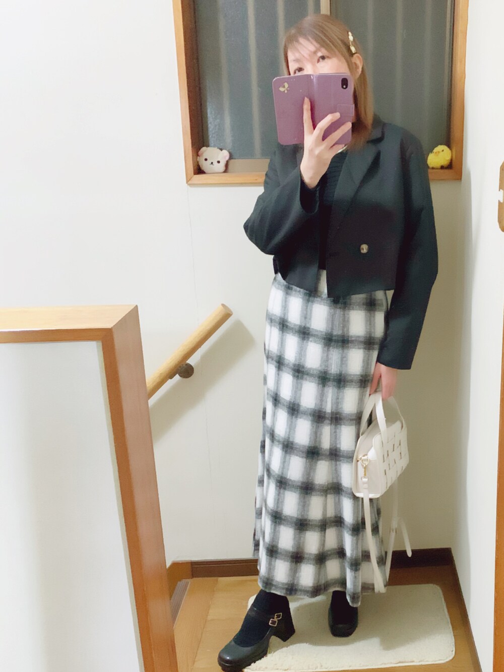 ブラック系のテーラードジャケット、ブラック系のパンプス、ホワイト系のスカートを着用したレディースの冬コーディネートの4枚目の写真