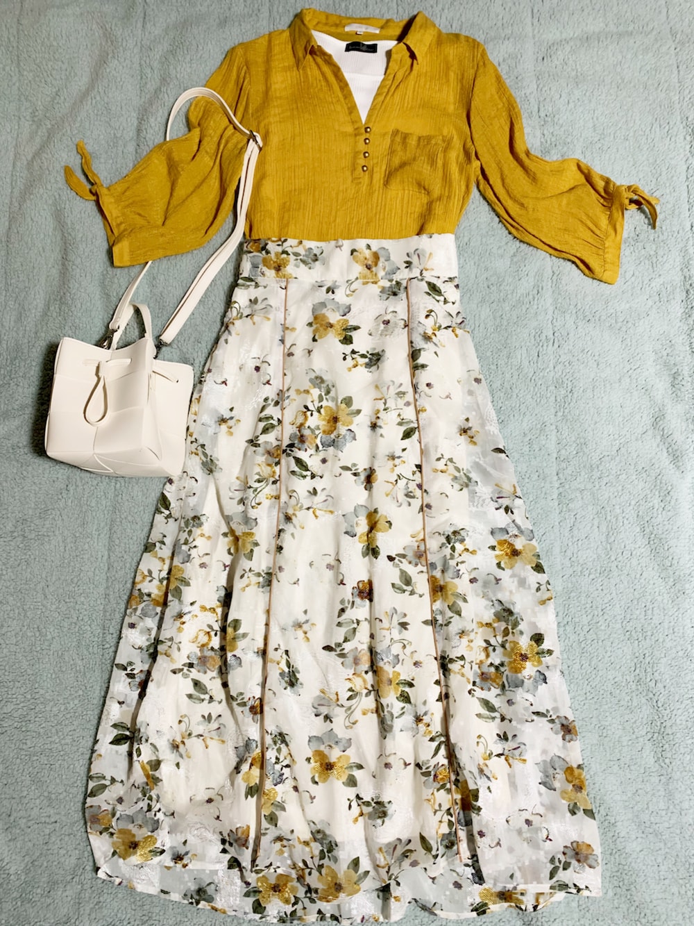 ホワイト系のサンダル、ホワイト系のショルダーバッグ、ホワイト系のスカートを着用したレディースの夏コーディネートの3枚目の写真