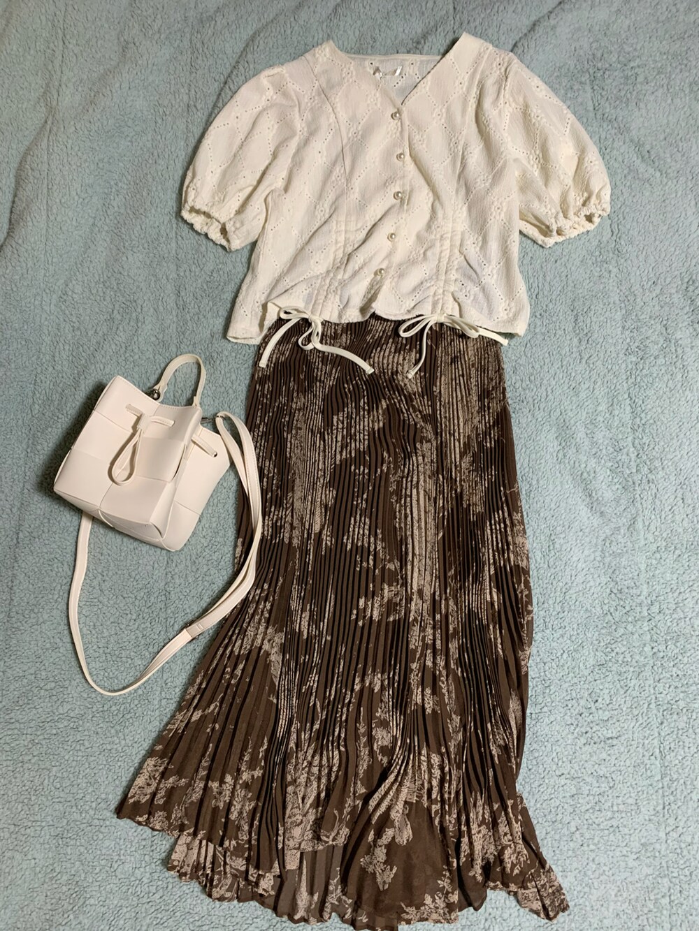 ブラウン系のサンダル、ブラウン系のスカート、ホワイト系のショルダーバッグを着用したレディースの夏コーディネートの3枚目の写真