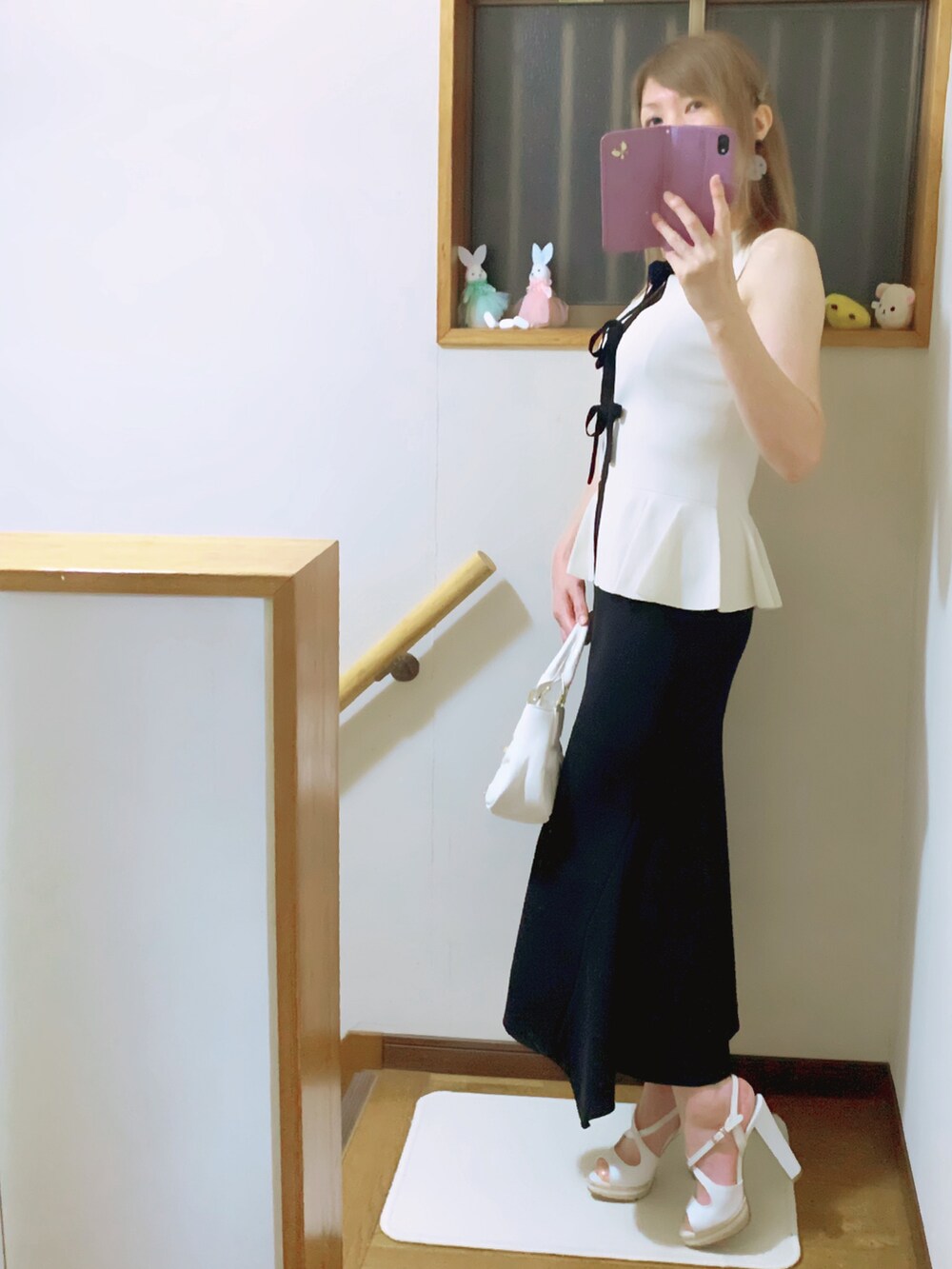 ブラック系のスカート、ホワイト系のショルダーバッグ、ホワイト系のニット/セーターを着用したレディースの夏コーディネートの3枚目の写真