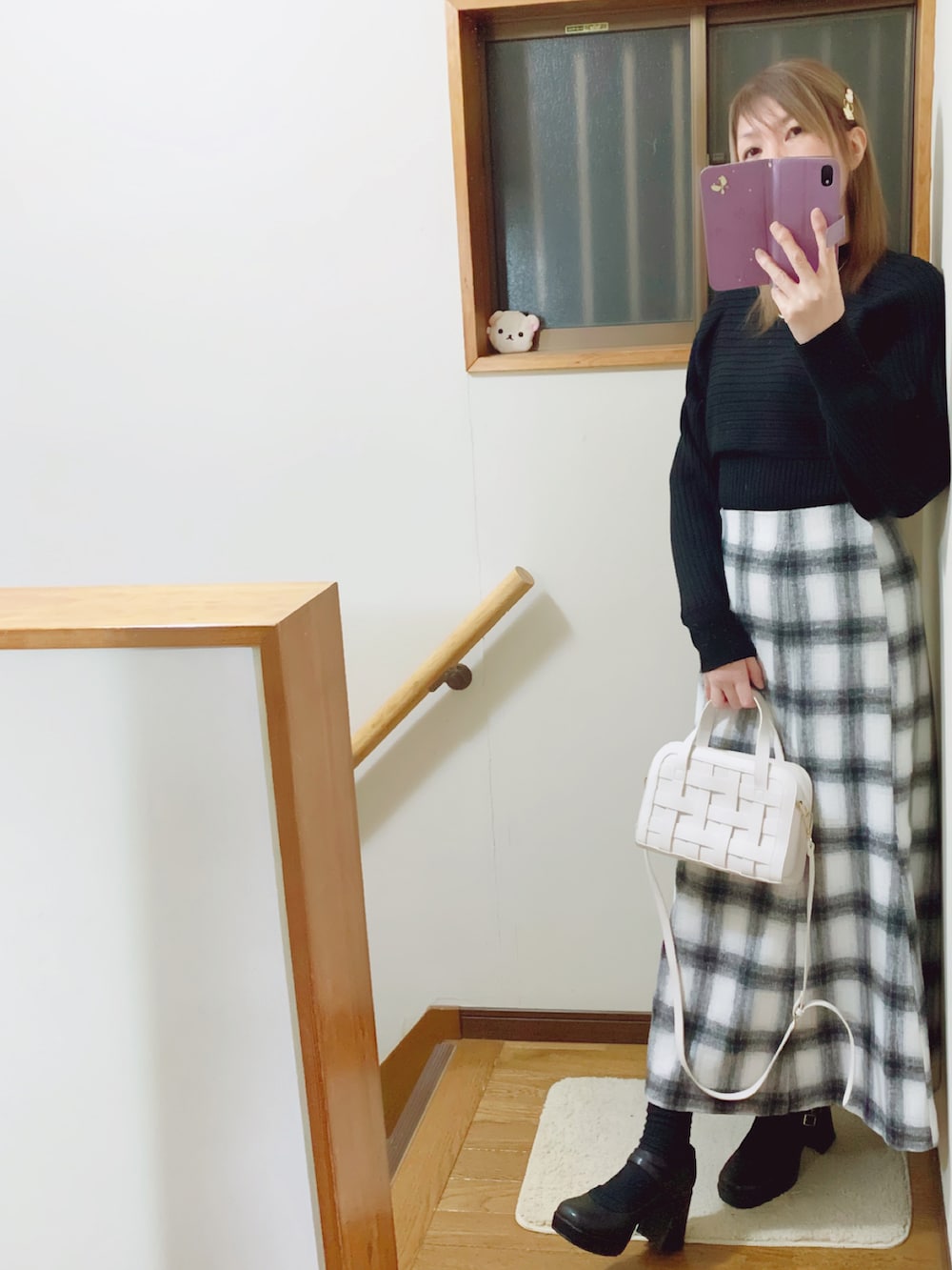 ブラック系のテーラードジャケット、ブラック系のパンプス、ホワイト系のスカートを着用したレディースの冬コーディネートの2枚目の写真