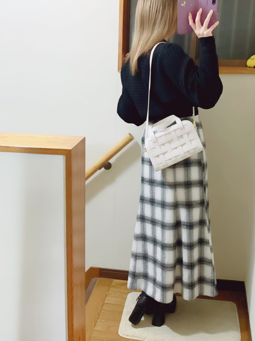 ブラック系のテーラードジャケット、ブラック系のパンプス、ホワイト系のスカートを着用したレディースの冬コーディネートの5枚目の写真