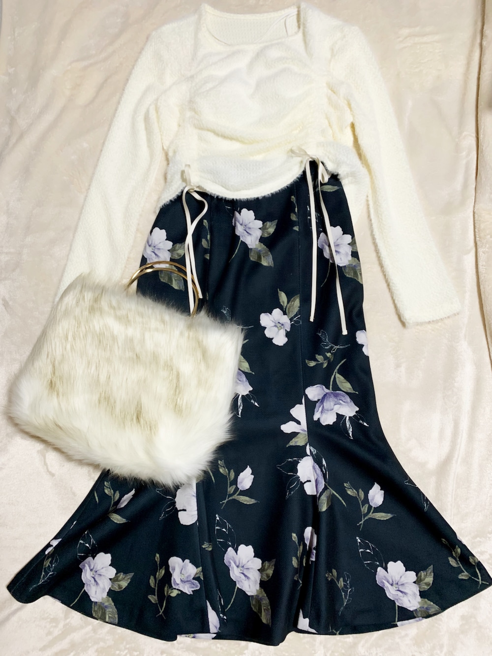 ブラック系のパンプス、ブラック系のスカート、ホワイト系のハンドバッグを着用したレディースの秋コーディネートの5枚目の写真