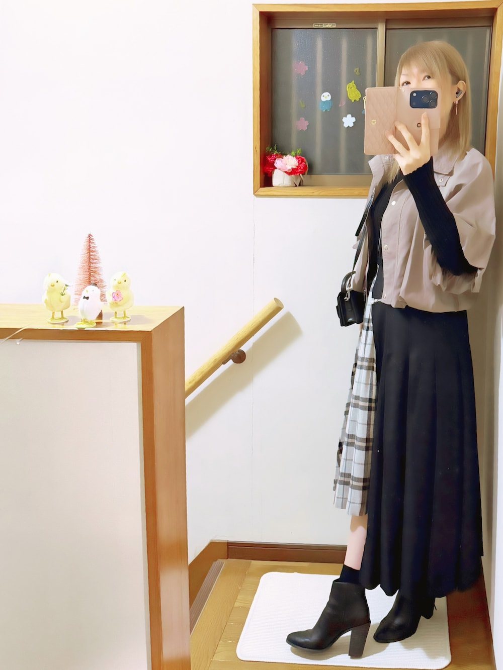 ブラック系のニット/セーター、ブラウン系のブルゾン、ブラック系のスカートを着用したレディースの春コーディネートの2枚目の写真