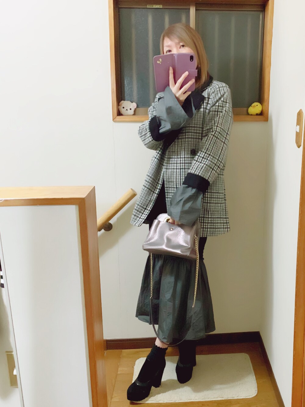 グレー系のハンドバッグ、グレー系のその他アウター、ブラック系のワンピースを着用したレディースの冬コーディネートの3枚目の写真