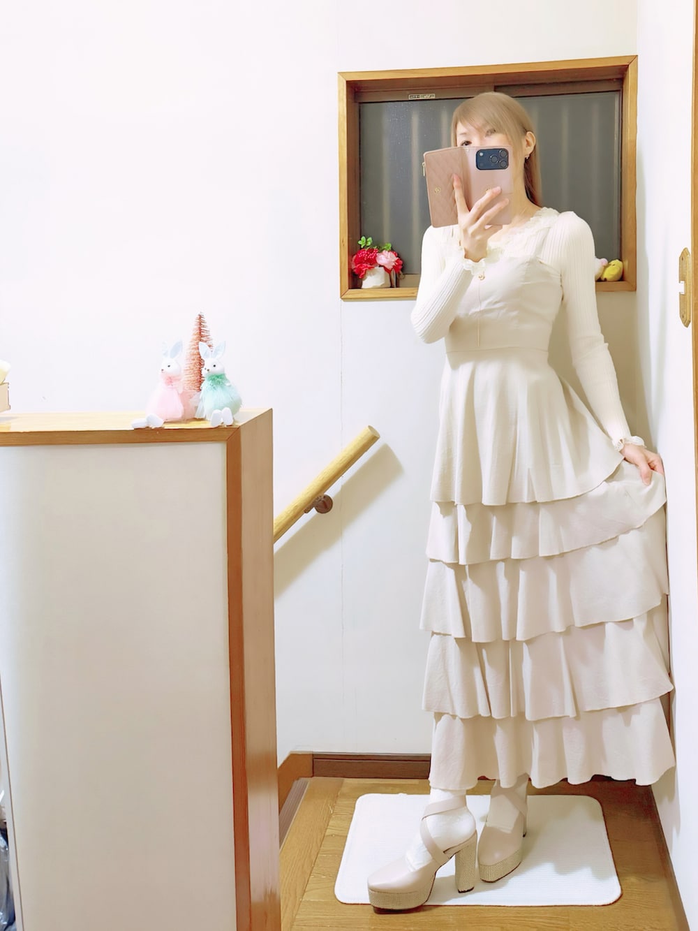 ベージュ系のワンピース、ベージュ系のサンダル、ホワイト系のニット/セーターを着用したレディースの冬コーディネートの3枚目の写真