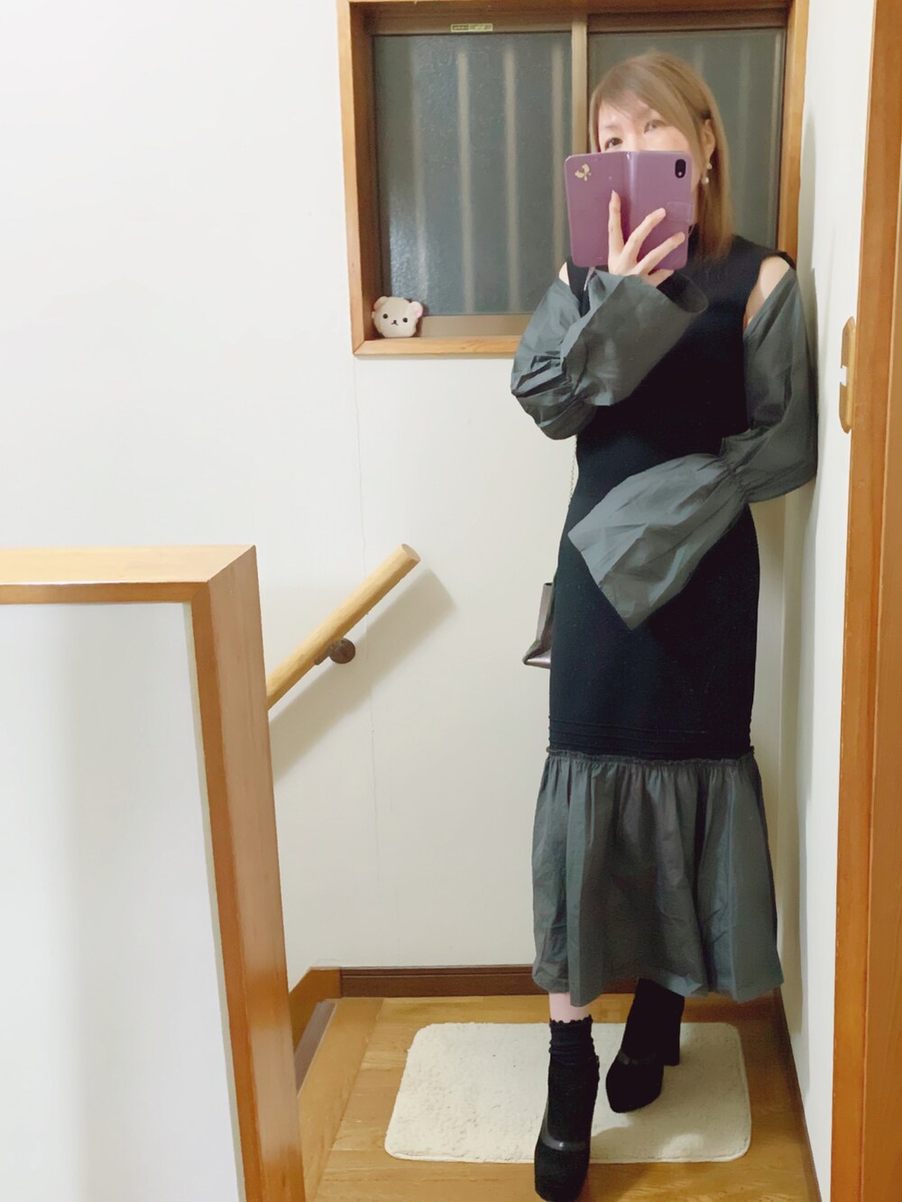 グレー系のハンドバッグ、グレー系のその他アウター、ブラック系のワンピースを着用したレディースの冬コーディネートの2枚目の写真