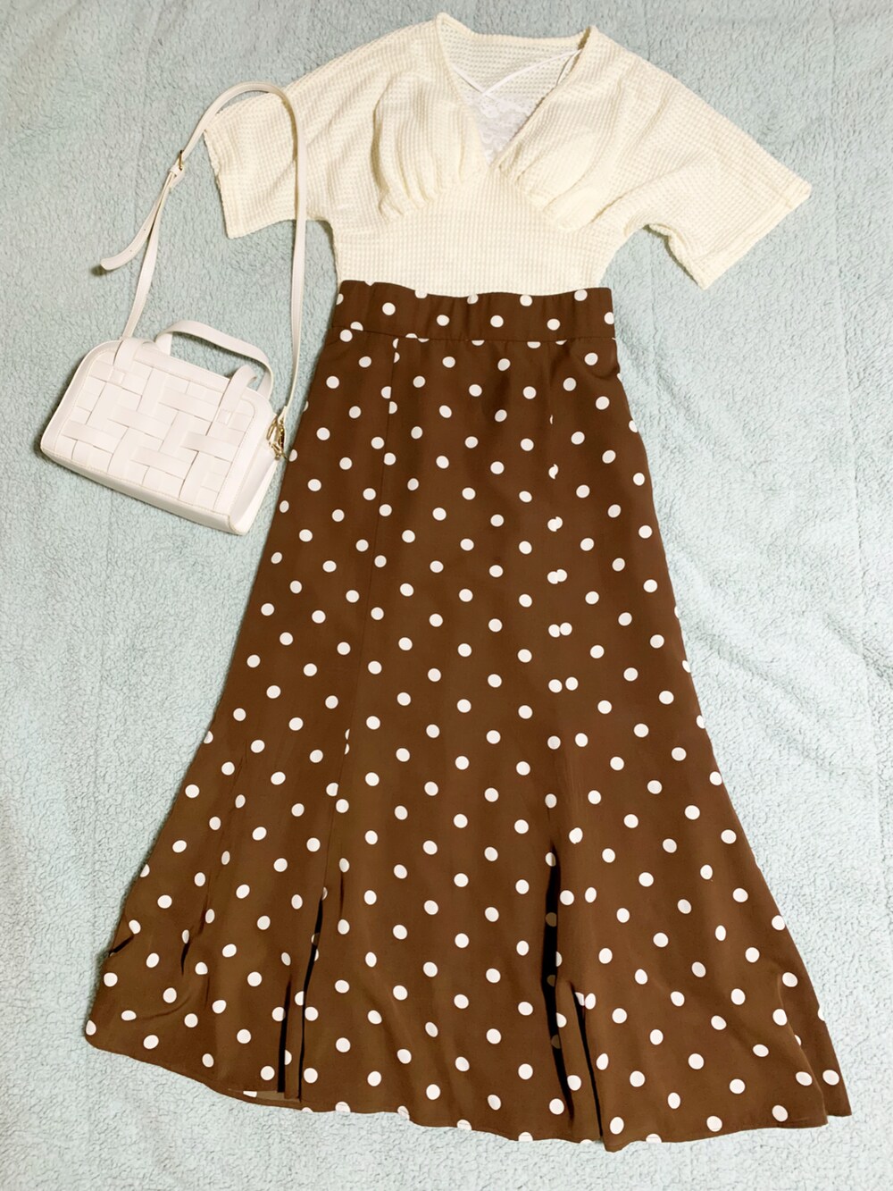 ホワイト系のサンダル、ブラウン系のスカート、ホワイト系のショルダーバッグを着用したレディースの夏コーディネートの3枚目の写真