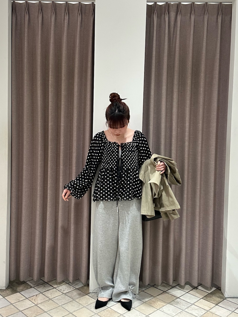 ブラック系のシャツ/ブラウス、グレー系のキャミソール、ベージュ系のトレンチコートを着用したレディースの冬コーディネートの2枚目の写真