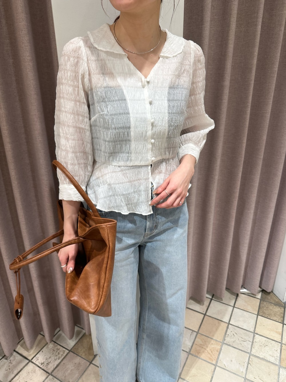 ホワイト系のシャツ/ブラウス、ブルー系のデニムパンツ、ブラック系のパンプスを着用したレディースの春コーディネートの5枚目の写真