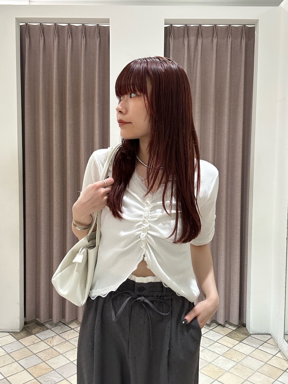 ホワイト系のTシャツ/カットソー、グレー系のスラックス、シルバー系のパンプスを着用したレディースの春コーディネートの3枚目の写真