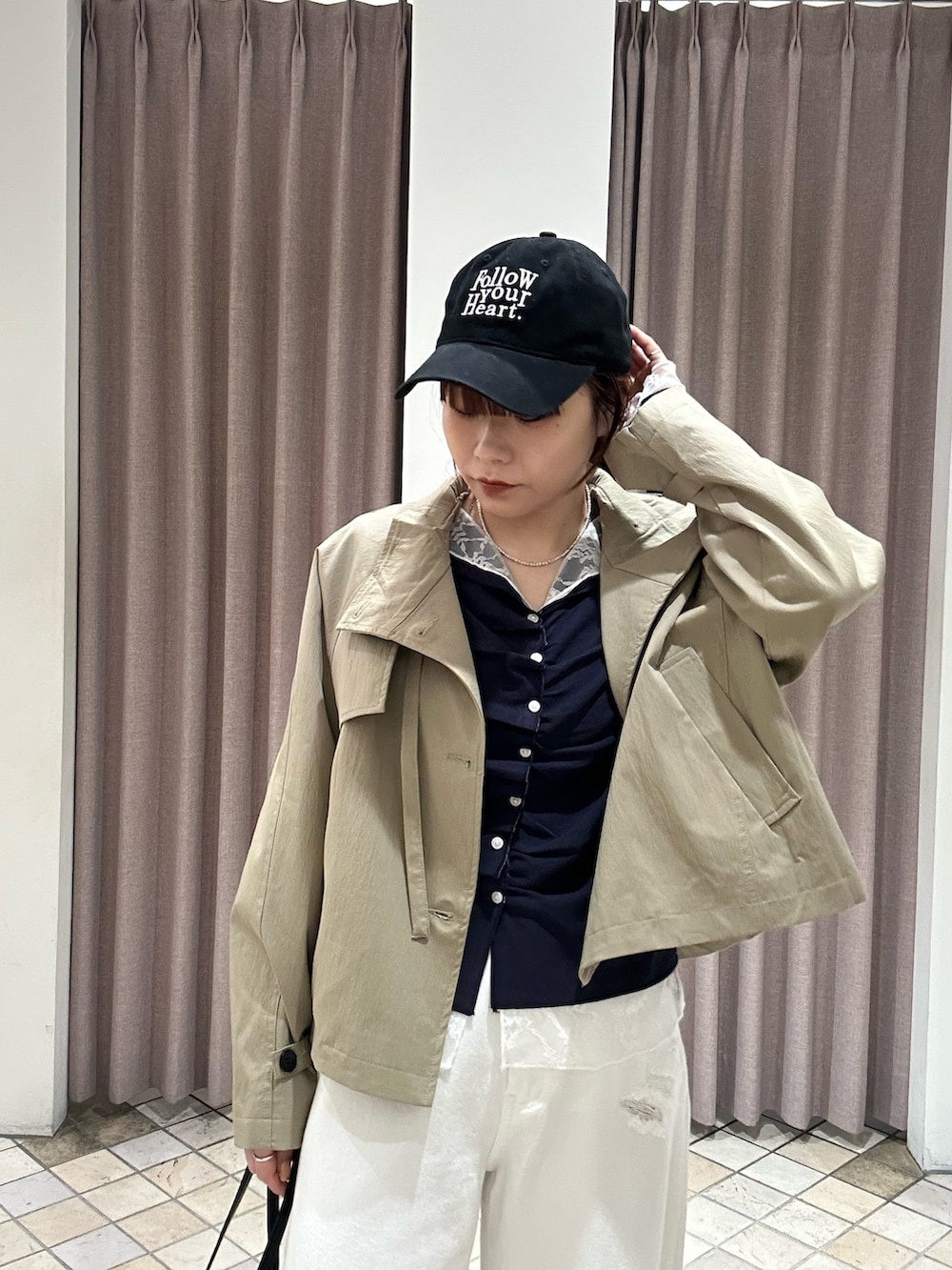 ホワイト系のデニムパンツ、ベージュ系のトレンチコート、ブルー系のTシャツ/カットソーを着用したレディースの冬コーディネートの3枚目の写真