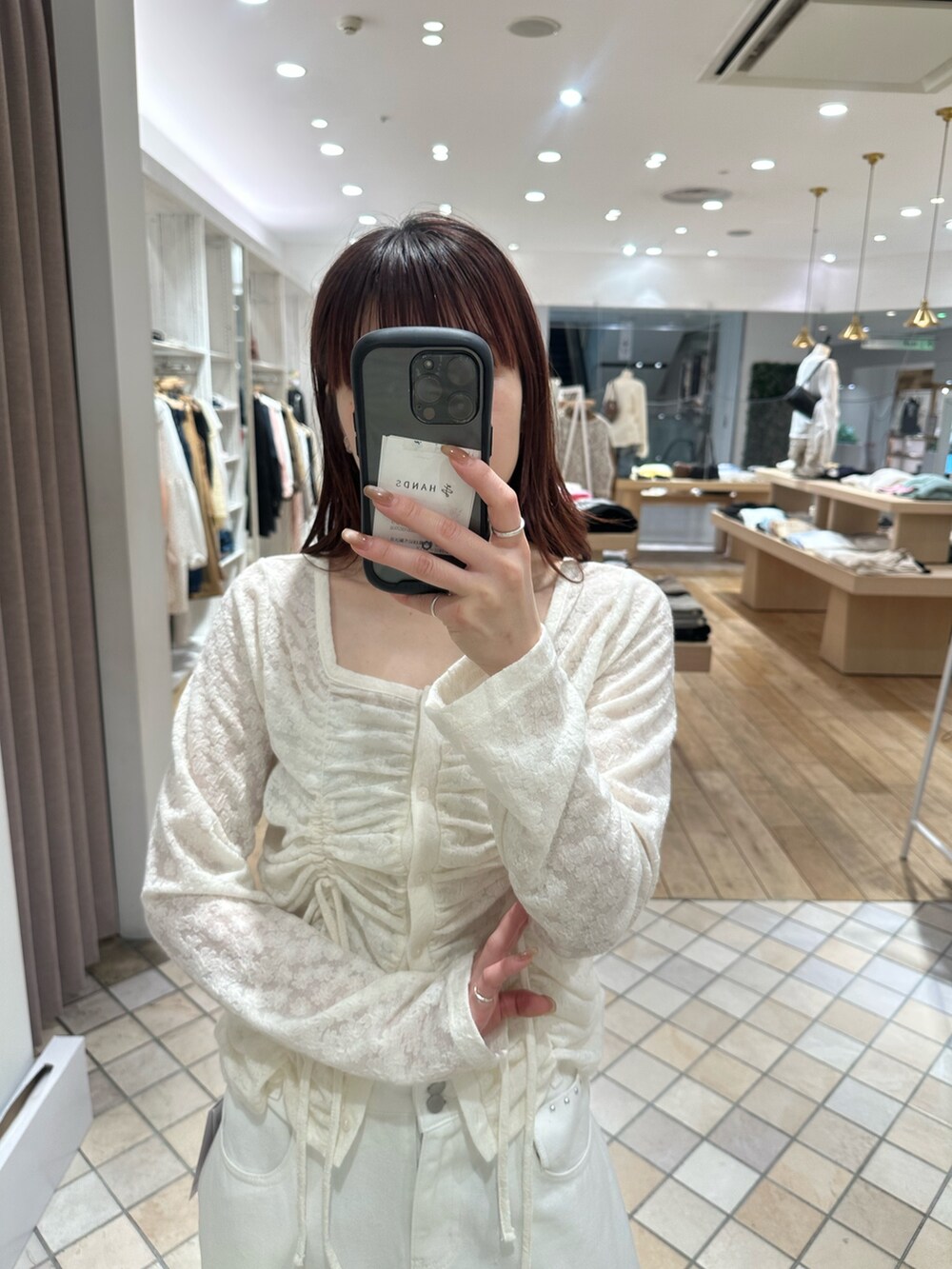 ホワイト系のカーディガン/ボレロ、ホワイト系のデニムパンツ、ホワイト系のキャミソールを着用したレディースの春コーディネートの4枚目の写真