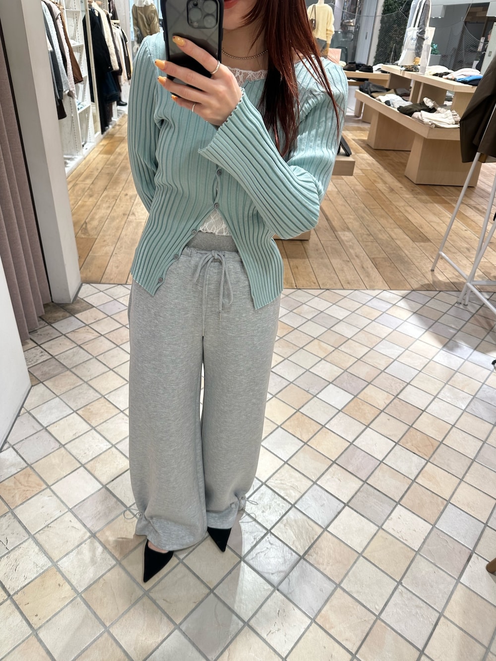 グリーン系のカーディガン/ボレロ、ホワイト系のキャミソール、ホワイト系のTシャツ/カットソーを着用したレディースの冬コーディネートの3枚目の写真