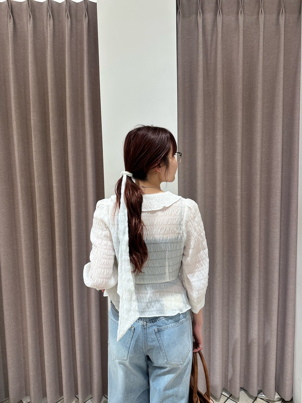 ホワイト系のシャツ/ブラウス、ブルー系のデニムパンツ、ブラック系のパンプスを着用したレディースの春コーディネートの3枚目の写真