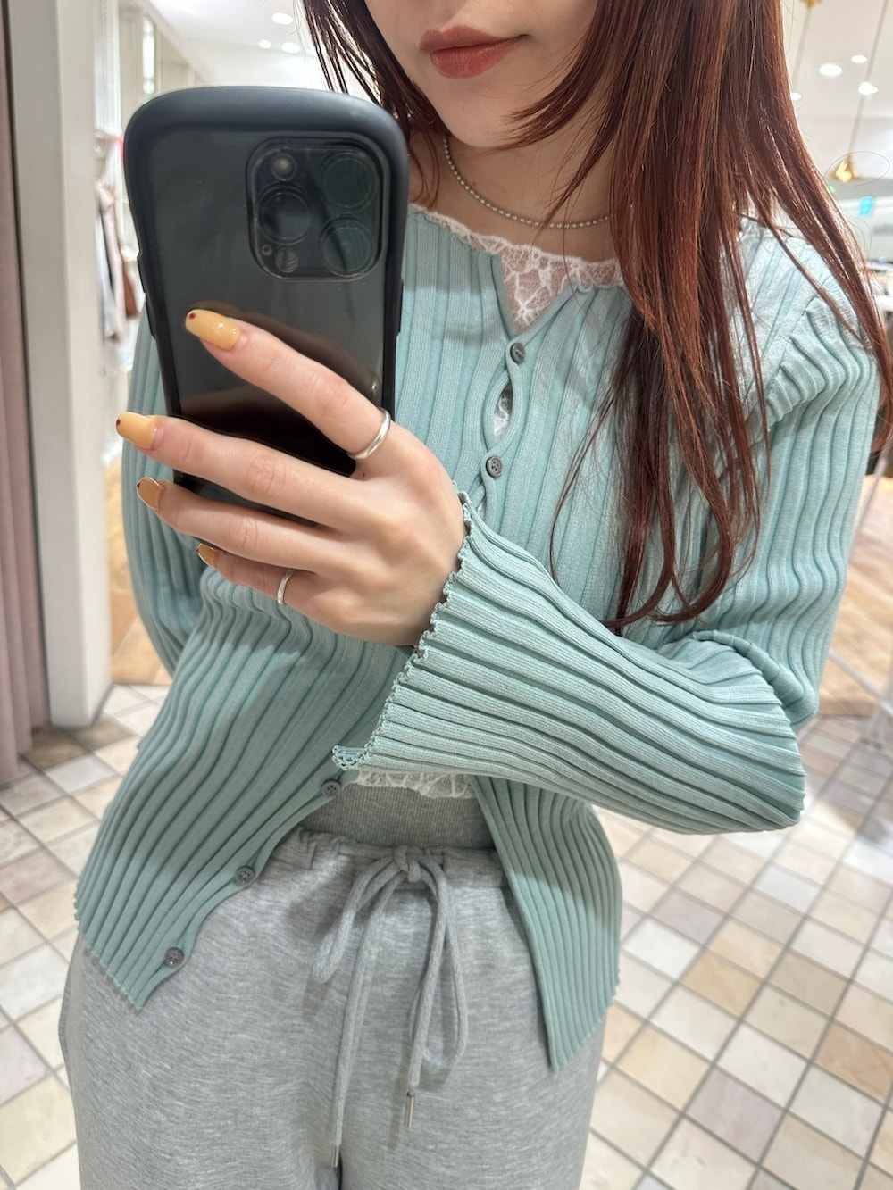 グリーン系のカーディガン/ボレロ、ホワイト系のキャミソール、ホワイト系のTシャツ/カットソーを着用したレディースの冬コーディネートの4枚目の写真