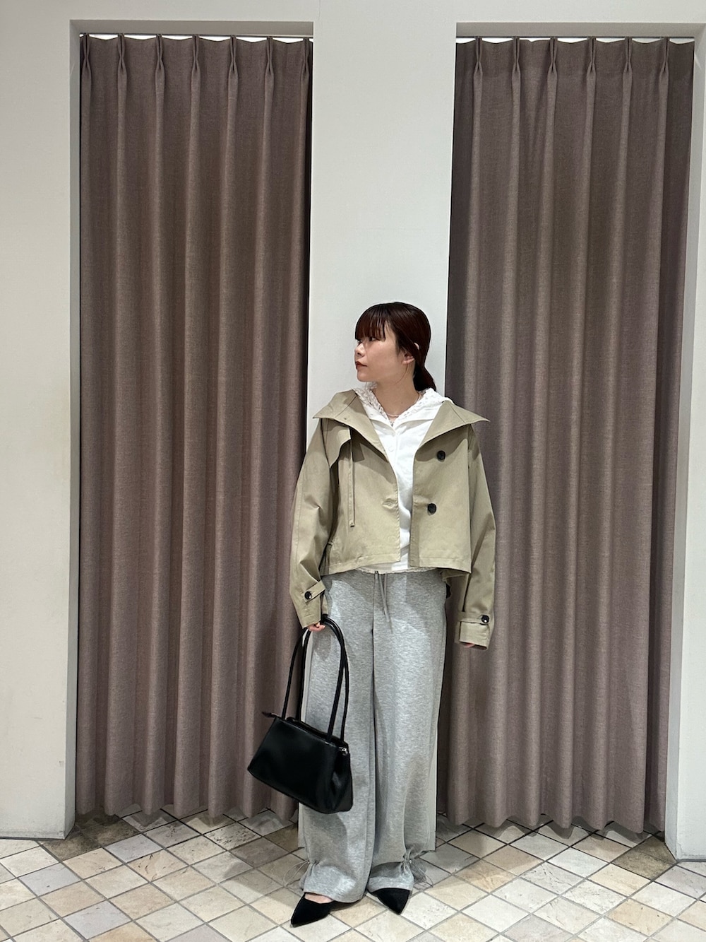 グレー系のスウェットパンツ、ブラック系のショルダーバッグ、ブラック系のパンプスを着用したレディースの冬コーディネートの2枚目の写真