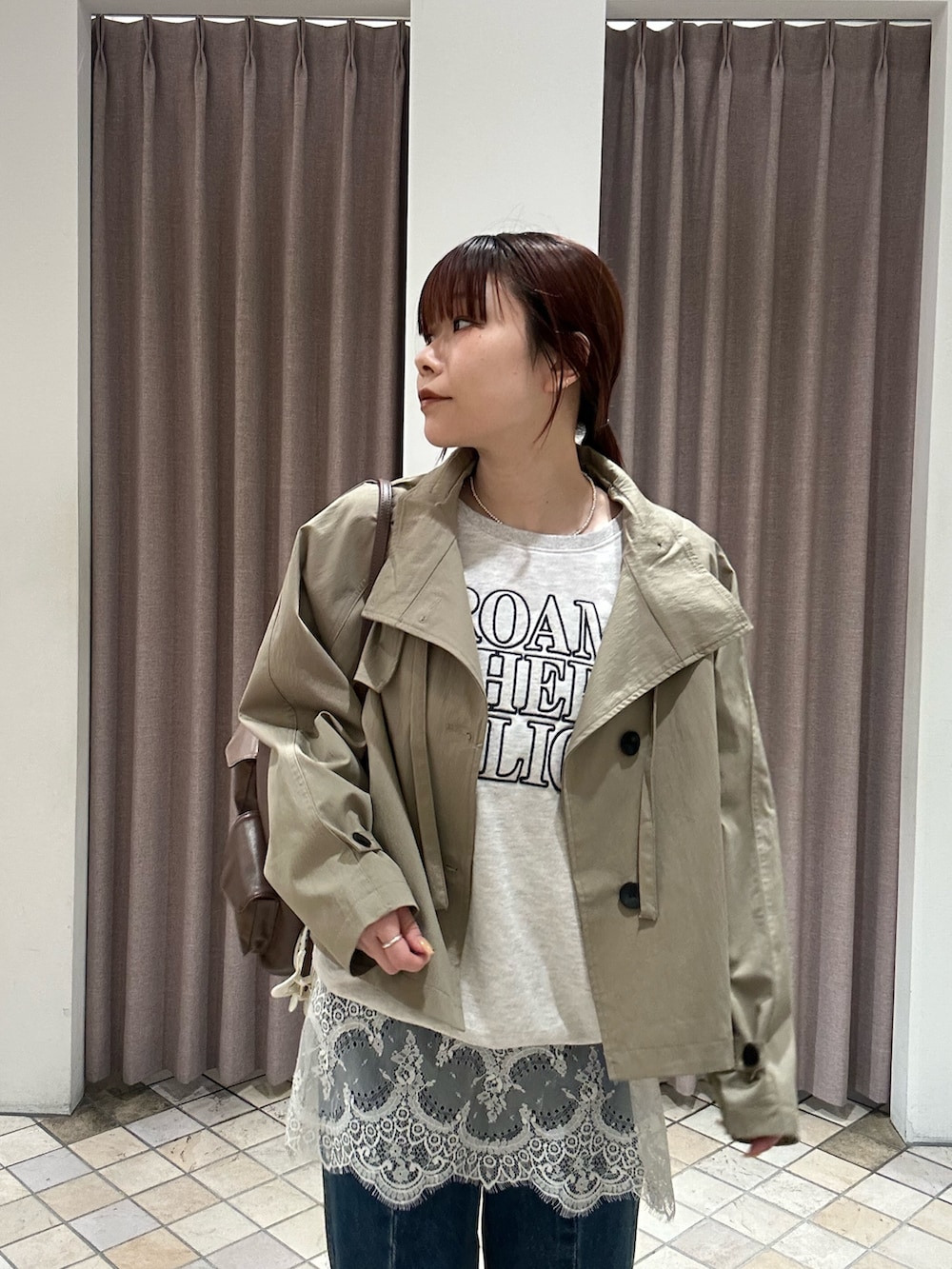 ベージュ系のトレンチコート、グレー系のパーカー、イエロー系のトートバッグを着用したレディースの冬コーディネートの3枚目の写真