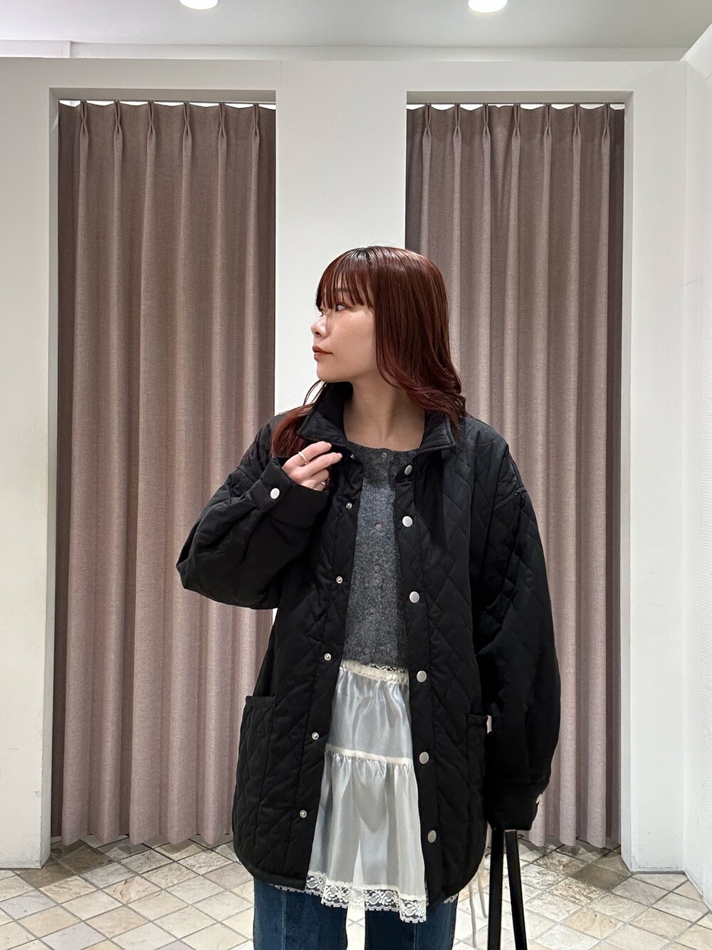 ブラック系のその他アウター、ブラック系のトートバッグ、ブルー系のデニムパンツを着用したレディースの秋コーディネートの3枚目の写真