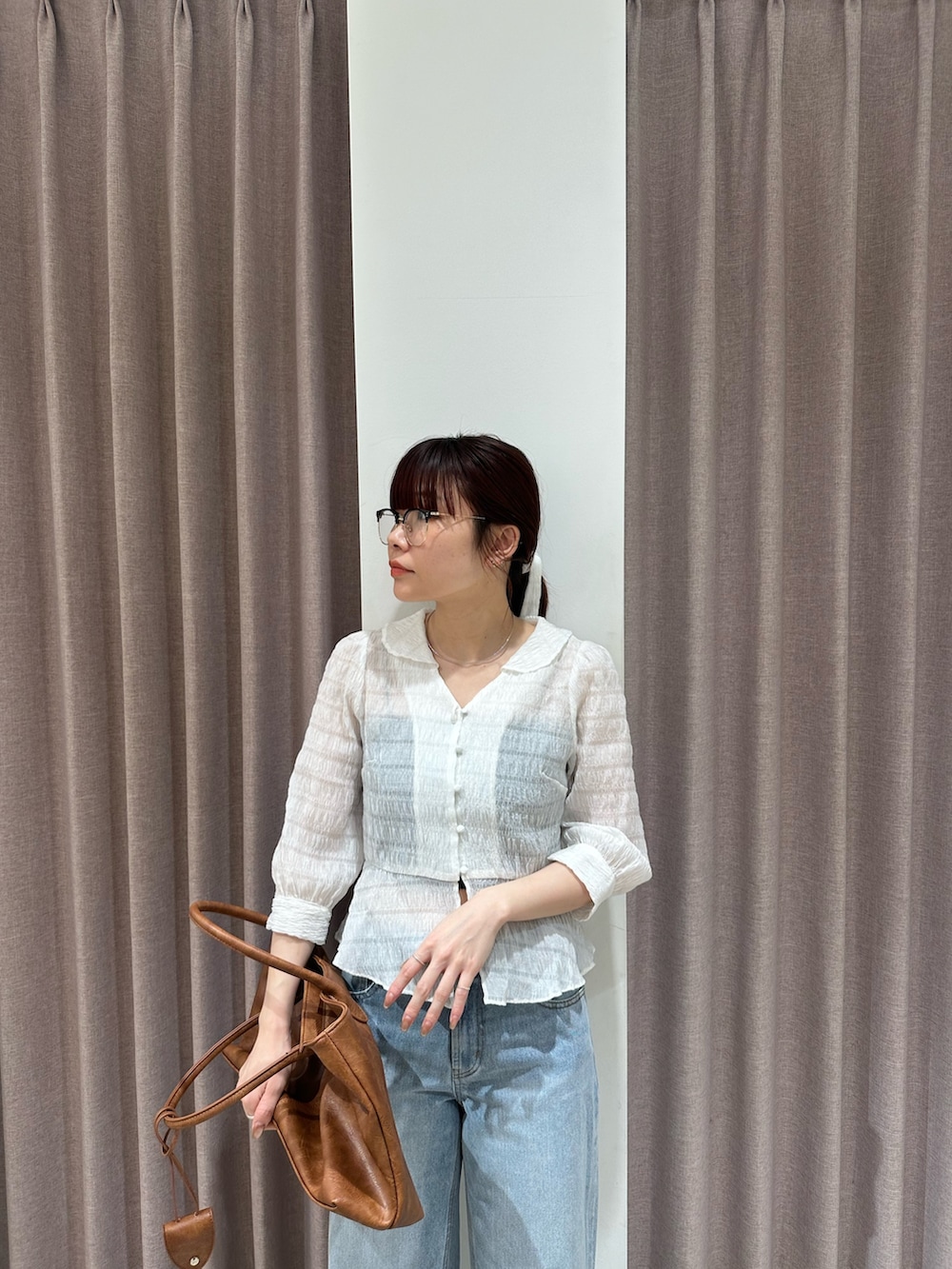 ホワイト系のシャツ/ブラウス、ブルー系のデニムパンツ、ブラック系のパンプスを着用したレディースの春コーディネートの4枚目の写真