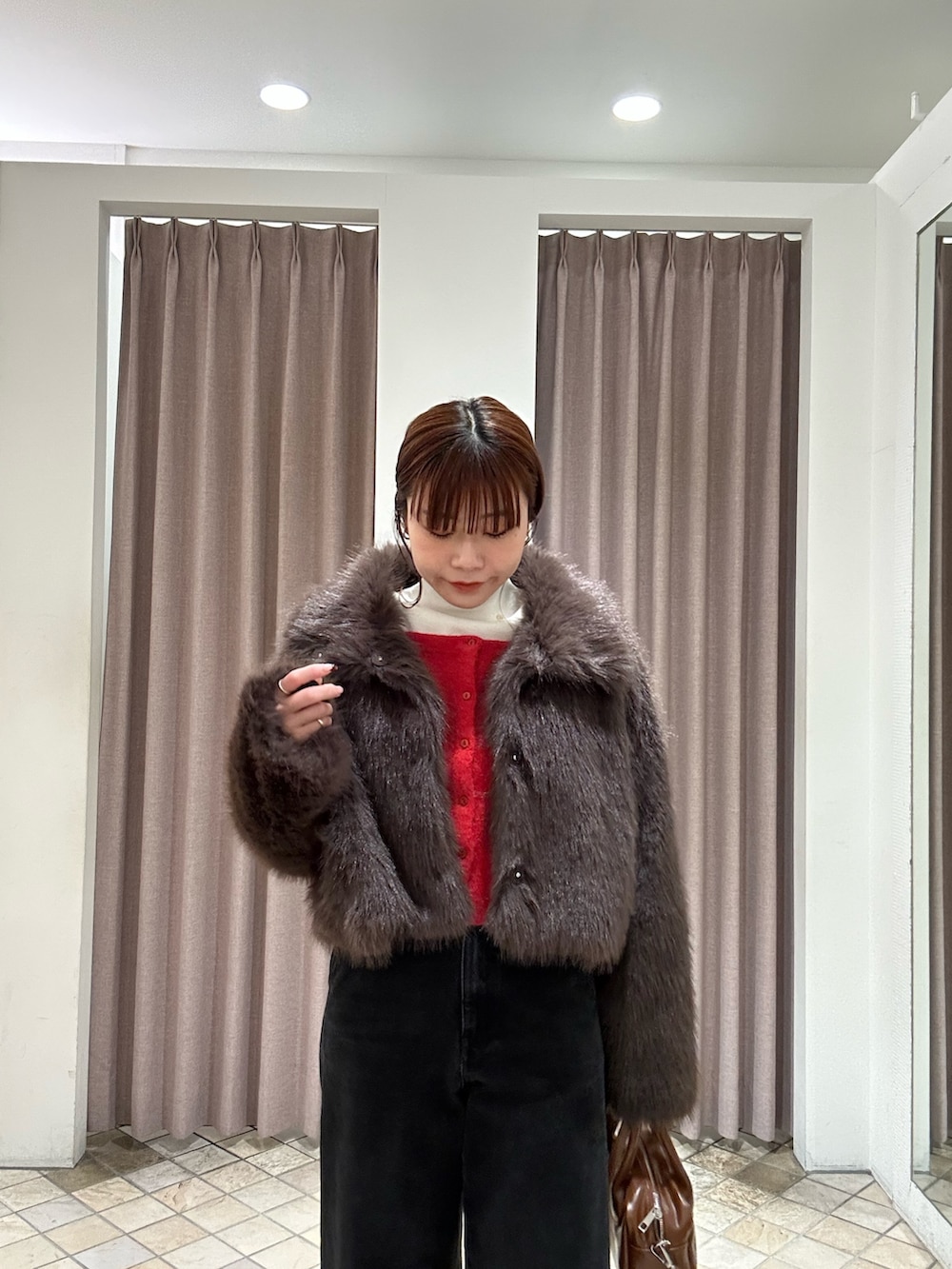 ブラウン系のその他アウター、ブラック系のデニムパンツ、イエロー系のボストンバッグを着用したレディースの秋コーディネートの2枚目の写真