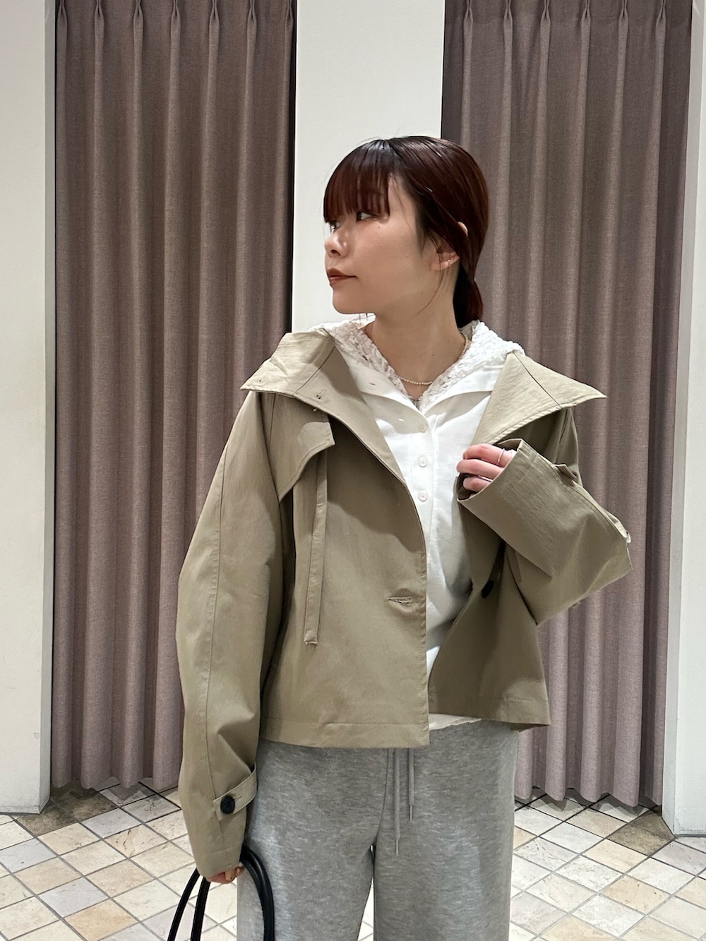 グレー系のスウェットパンツ、ブラック系のショルダーバッグ、ブラック系のパンプスを着用したレディースの冬コーディネートの3枚目の写真