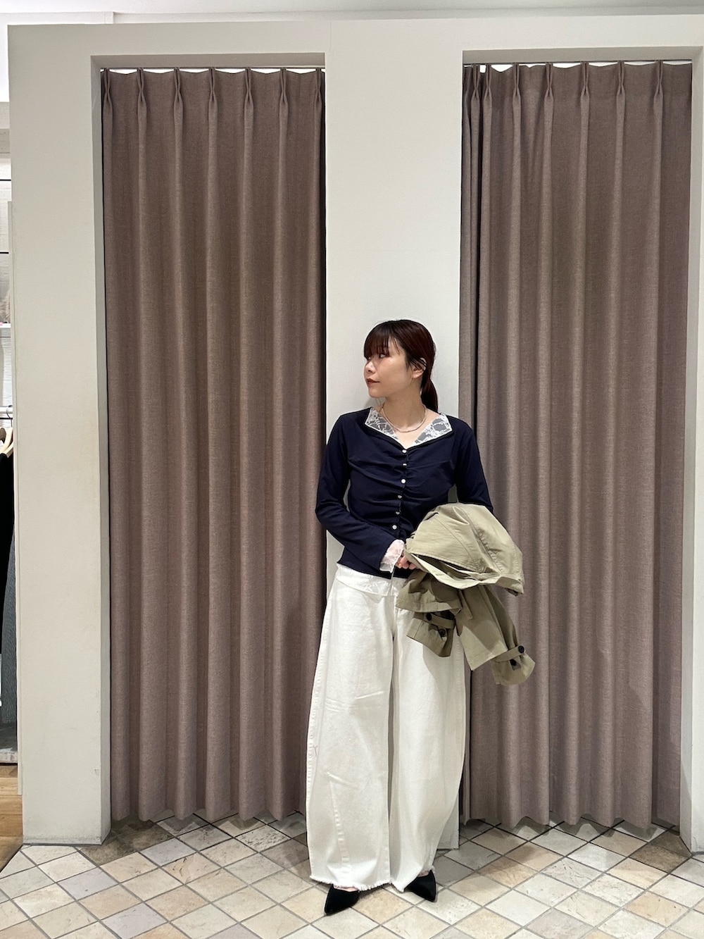 ホワイト系のデニムパンツ、ベージュ系のトレンチコート、ブルー系のTシャツ/カットソーを着用したレディースの冬コーディネートの4枚目の写真