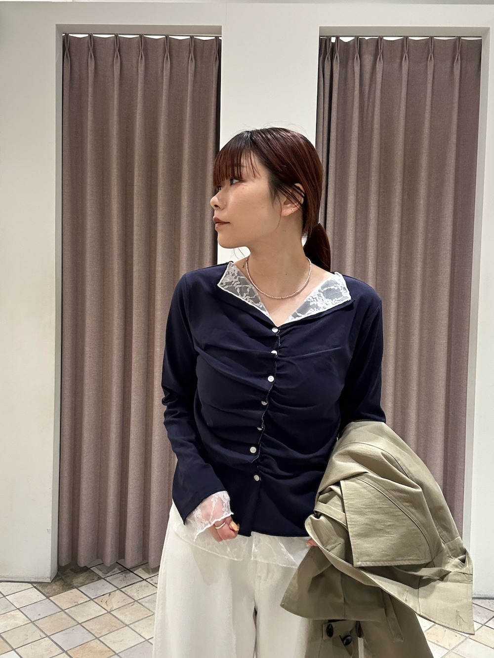 ホワイト系のデニムパンツ、ベージュ系のトレンチコート、ブルー系のTシャツ/カットソーを着用したレディースの冬コーディネートの5枚目の写真