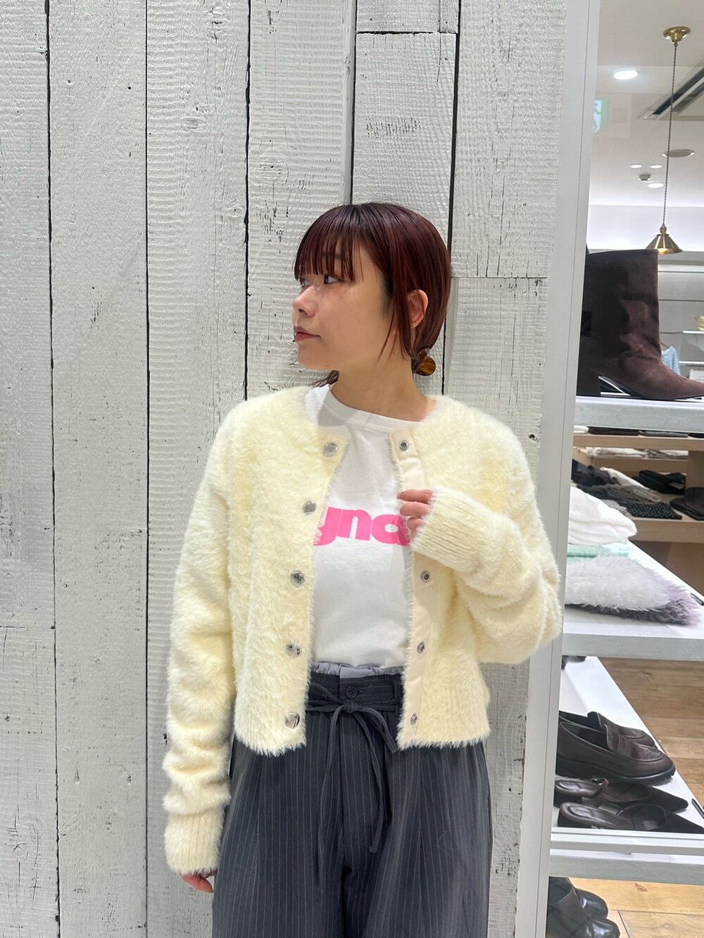 グレー系のスラックス、ホワイト系のカーディガン/ボレロ、ホワイト系のTシャツ/カットソーを着用したレディースの冬コーディネートの4枚目の写真