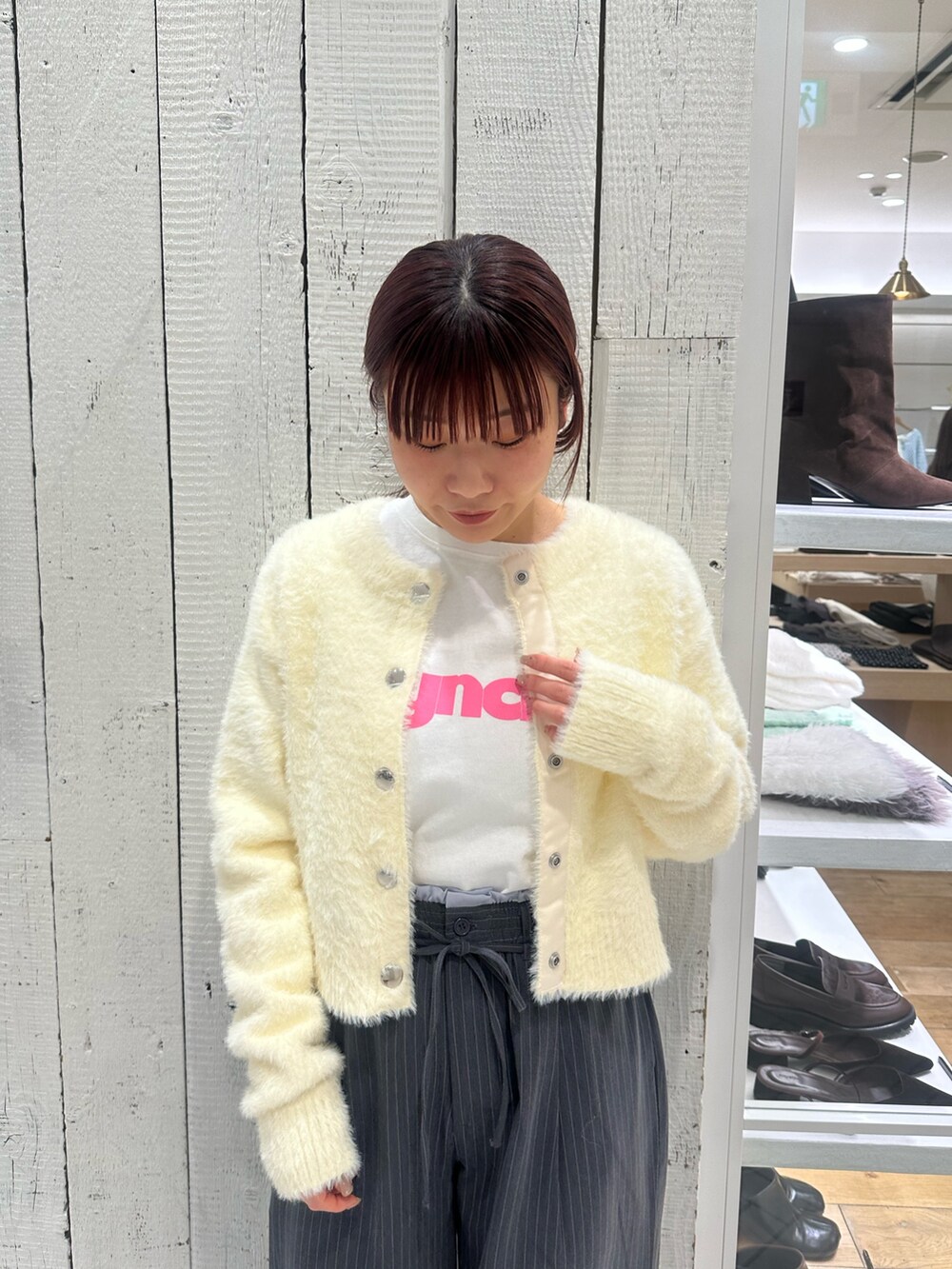 グレー系のスラックス、ホワイト系のカーディガン/ボレロ、ホワイト系のTシャツ/カットソーを着用したレディースの冬コーディネートの3枚目の写真