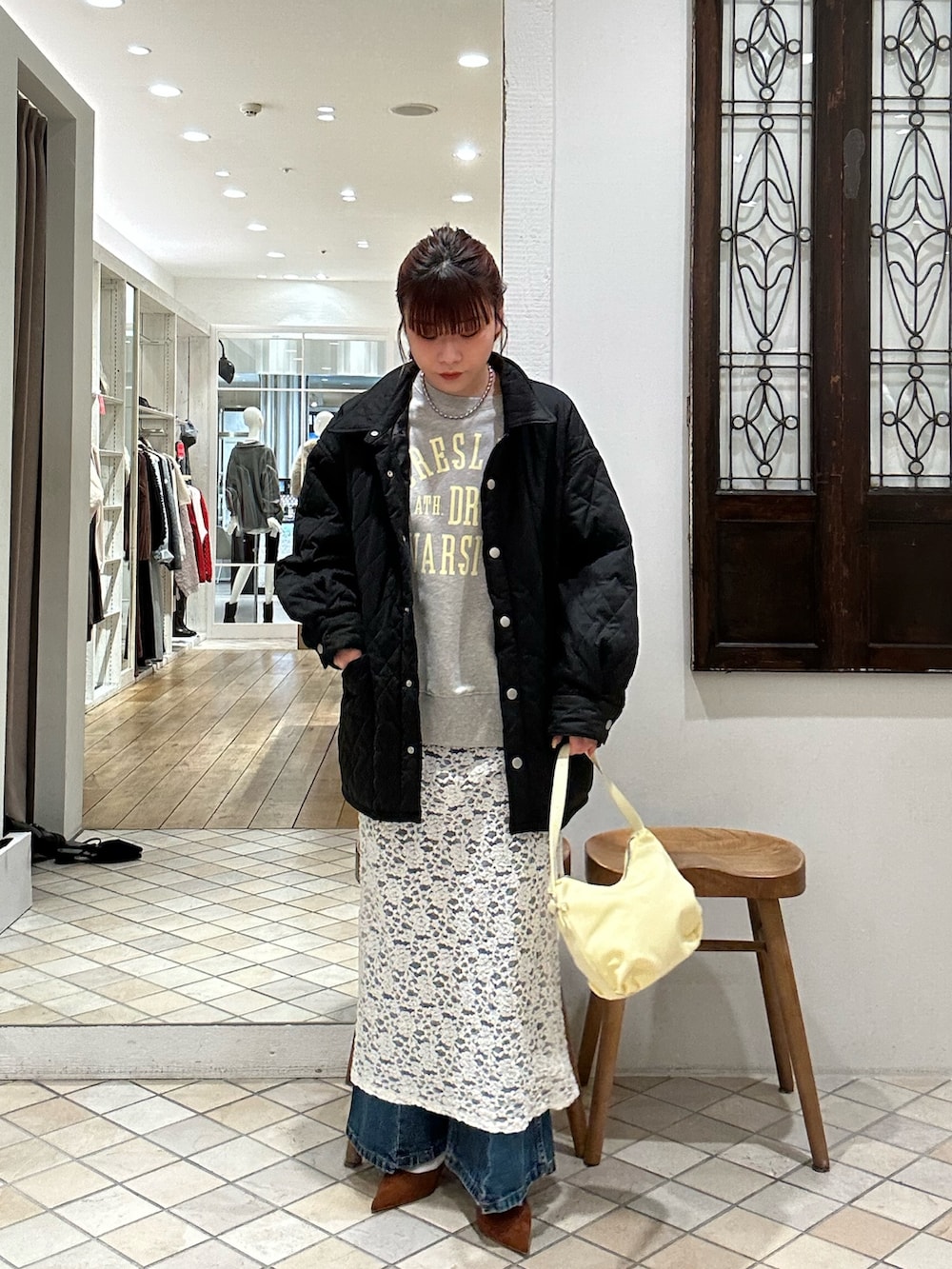 グレー系のTシャツ/カットソー、ブラック系のその他アウター、ホワイト系のスカートを着用したレディースの冬コーディネートの2枚目の写真