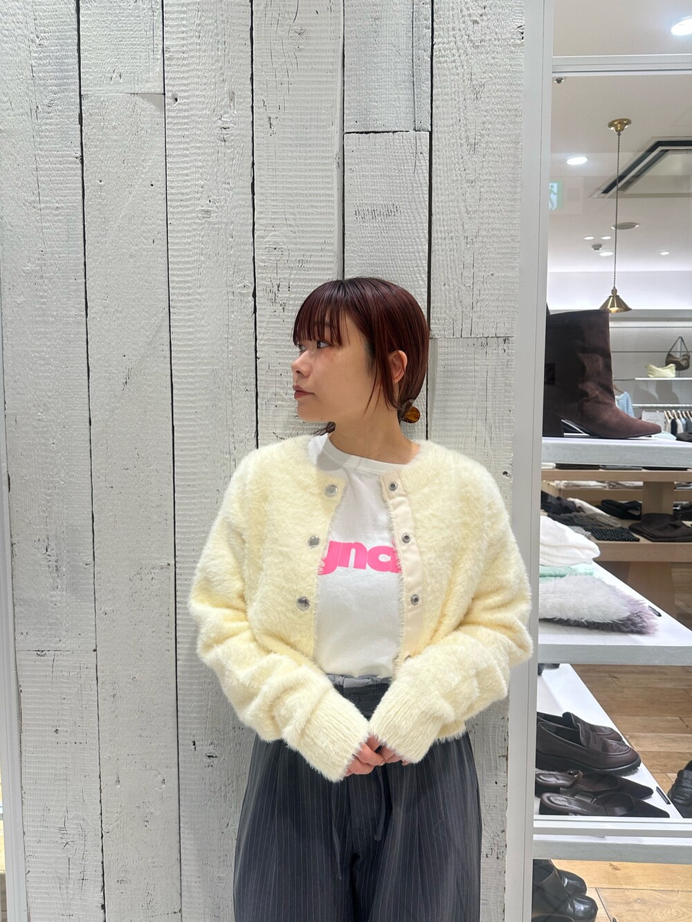 グレー系のスラックス、ホワイト系のカーディガン/ボレロ、ホワイト系のTシャツ/カットソーを着用したレディースの冬コーディネートの5枚目の写真