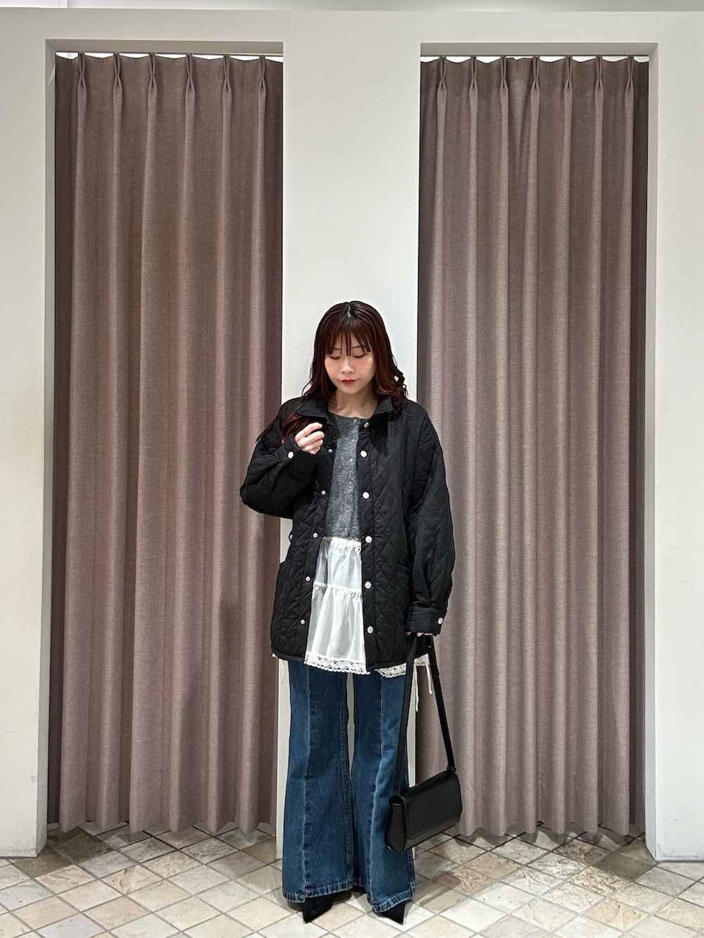 ブラック系のその他アウター、ブラック系のトートバッグ、ブルー系のデニムパンツを着用したレディースの秋コーディネートの2枚目の写真