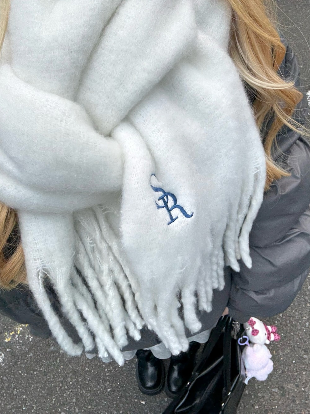 グレー系のスカート、ブラック系のボストンバッグ、グレー系のダウンジャケット/コートを着用したレディースの秋コーディネートの3枚目の写真