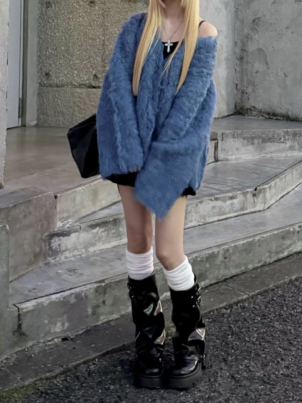 ブルー系のカーディガン/ボレロ、ブラック系のスカート、ブラック系のボストンバッグを着用したレディースの冬コーディネートの3枚目の写真