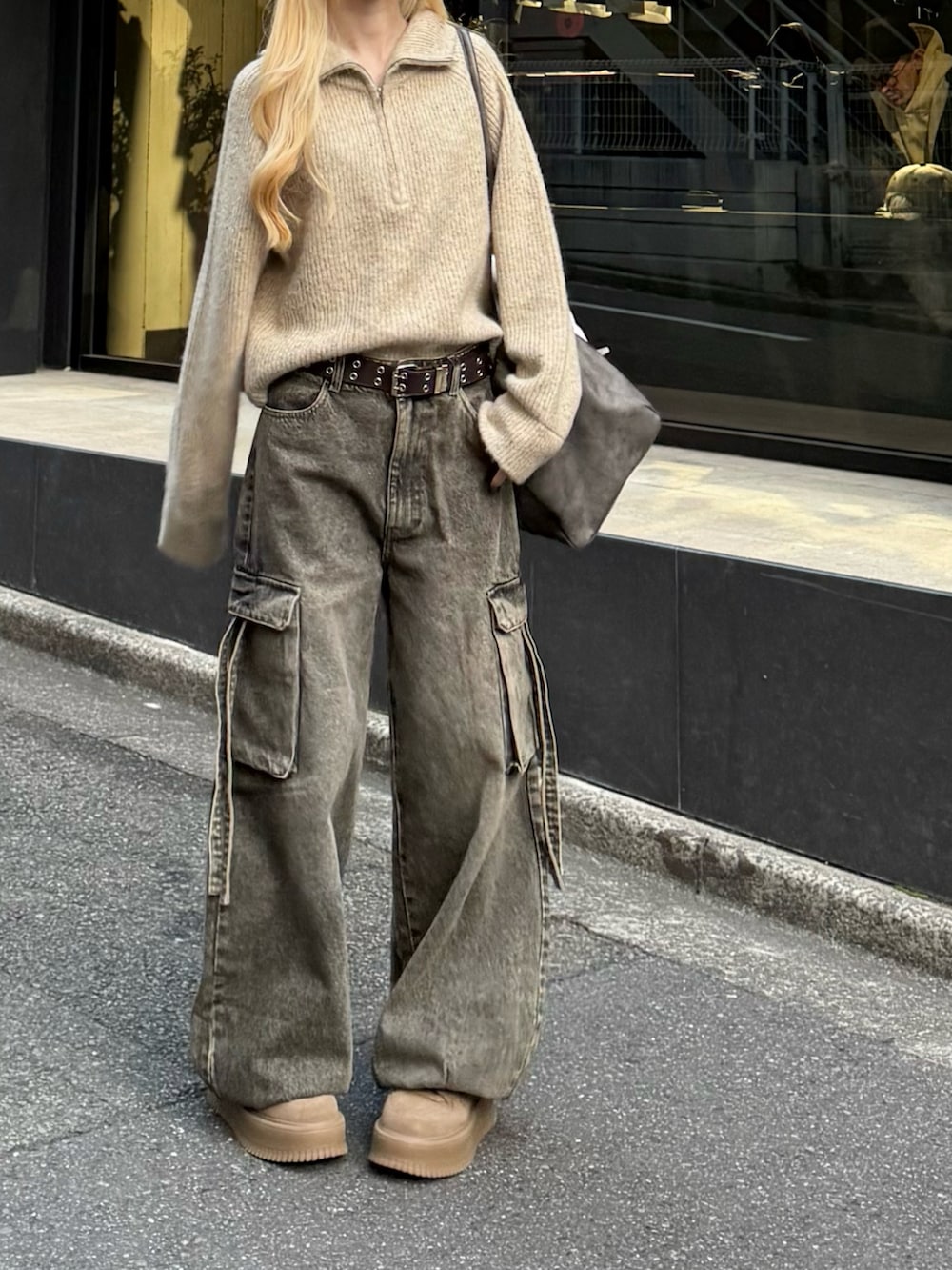 ベージュ系のニット/セーター、グレー系のボストンバッグ、ブラウン系のデニムパンツを着用したレディースの冬コーディネートの3枚目の写真