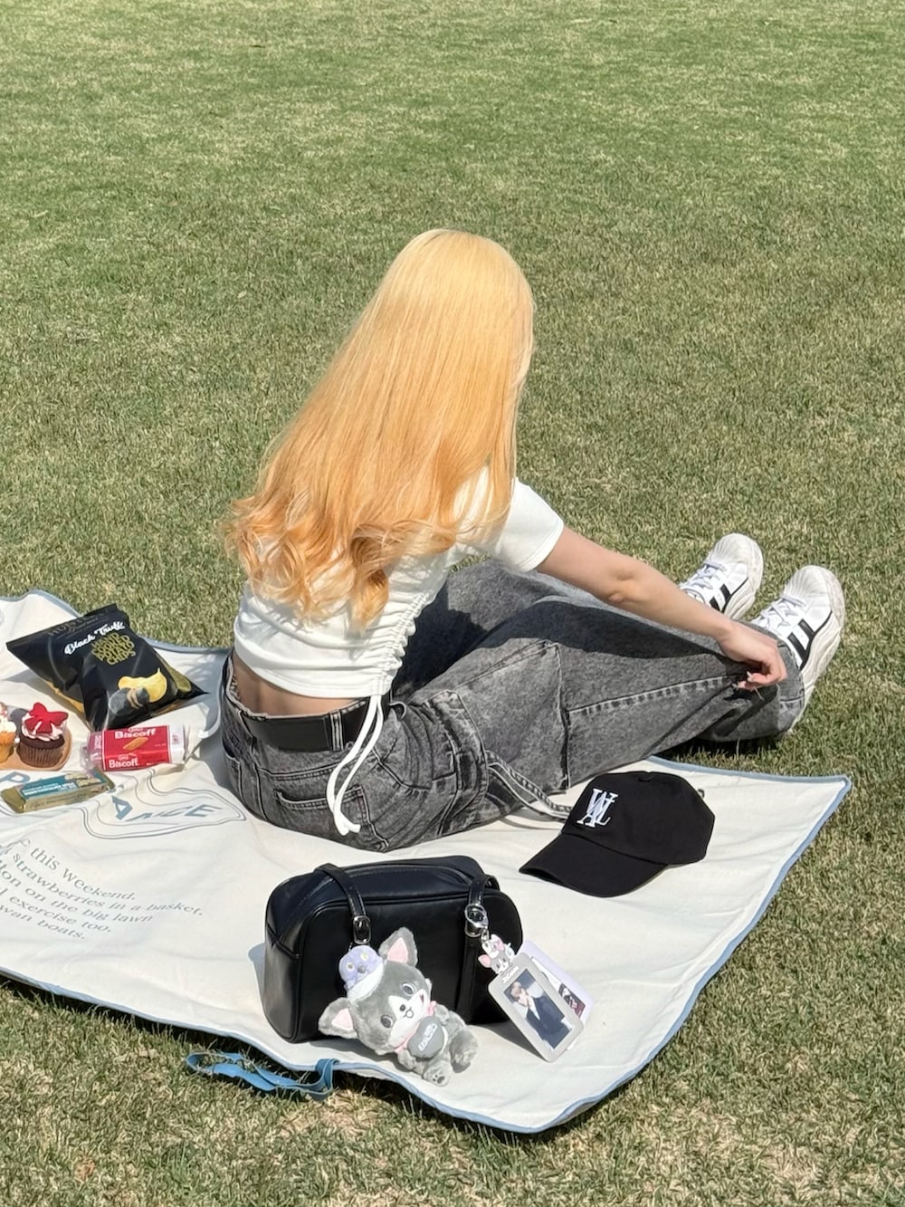 ホワイト系のTシャツ/カットソー、グレー系のデニムパンツ、ホワイト系のスニーカーを着用したレディースの春コーディネートの4枚目の写真