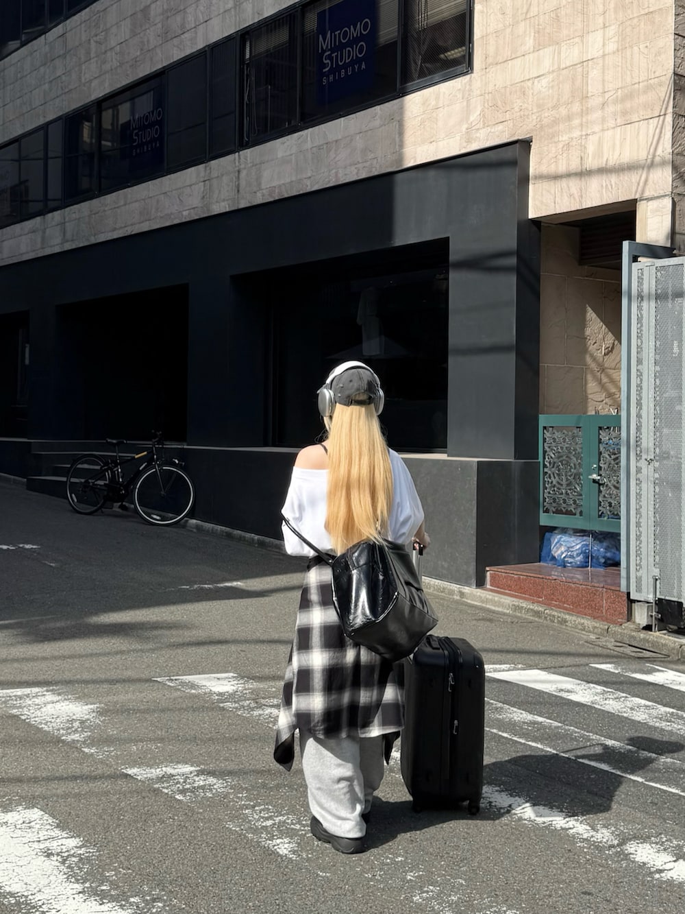ブラック系のスニーカー、ホワイト系のTシャツ/カットソー、ブラック系のボストンバッグを着用したレディースの夏コーディネートの3枚目の写真