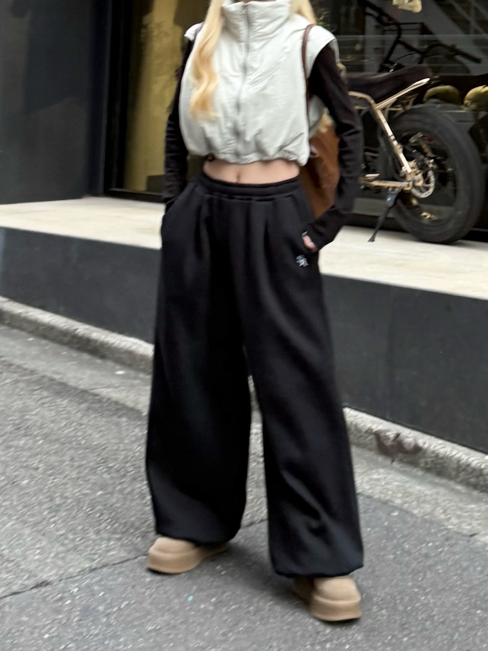 ブラック系のスウェットパンツ、ブラウン系のボストンバッグ、グレー系のトップスを着用したレディースの秋コーディネートの4枚目の写真