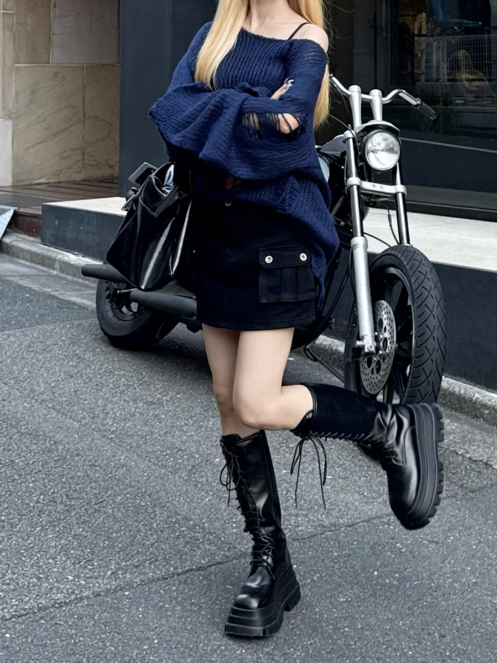ブラック系のブーツ、ブルー系のニット/セーター、ブラック系のスカートを着用したレディースの秋コーディネートの3枚目の写真