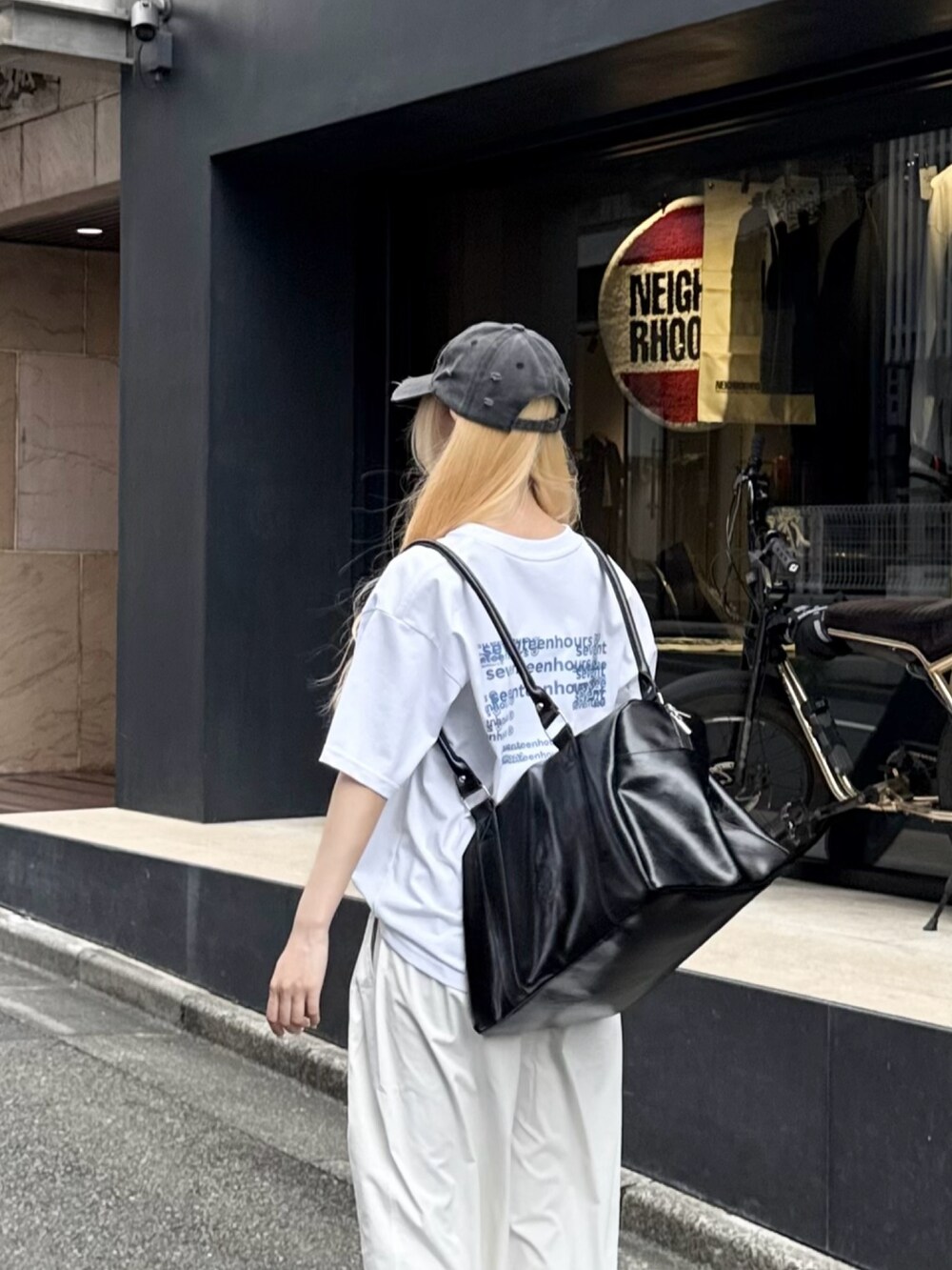 ブラック系のスニーカー、ホワイト系のTシャツ/カットソー、ホワイト系のパンツを着用したレディースの夏コーディネートの4枚目の写真