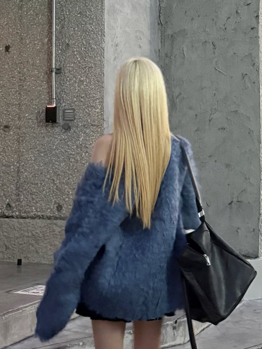 ブルー系のカーディガン/ボレロ、ブラック系のスカート、ブラック系のボストンバッグを着用したレディースの冬コーディネートの5枚目の写真