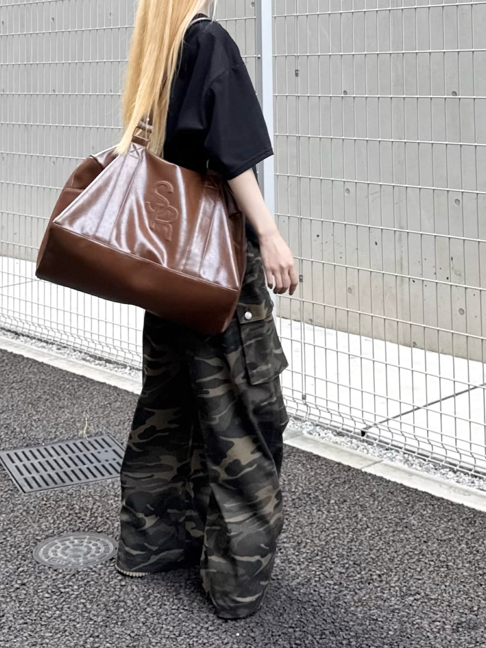 ブラック系のTシャツ/カットソー、その他のカーゴパンツ、ブラウン系のボストンバッグを着用したレディースの夏コーディネートの3枚目の写真