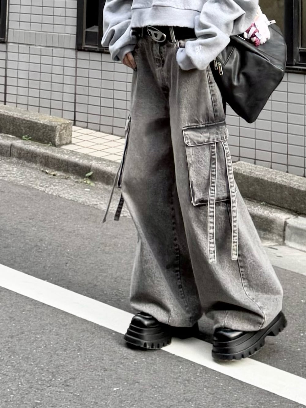 グレー系のスウェット、グレー系のデニムパンツ、ブラック系のボストンバッグを着用したレディースの冬コーディネートの5枚目の写真