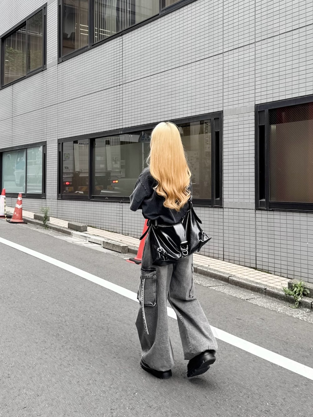 グレー系のデニムパンツ、ブラック系のTシャツ/カットソー、ブラック系のショルダーバッグを着用したレディースの夏コーディネートの4枚目の写真