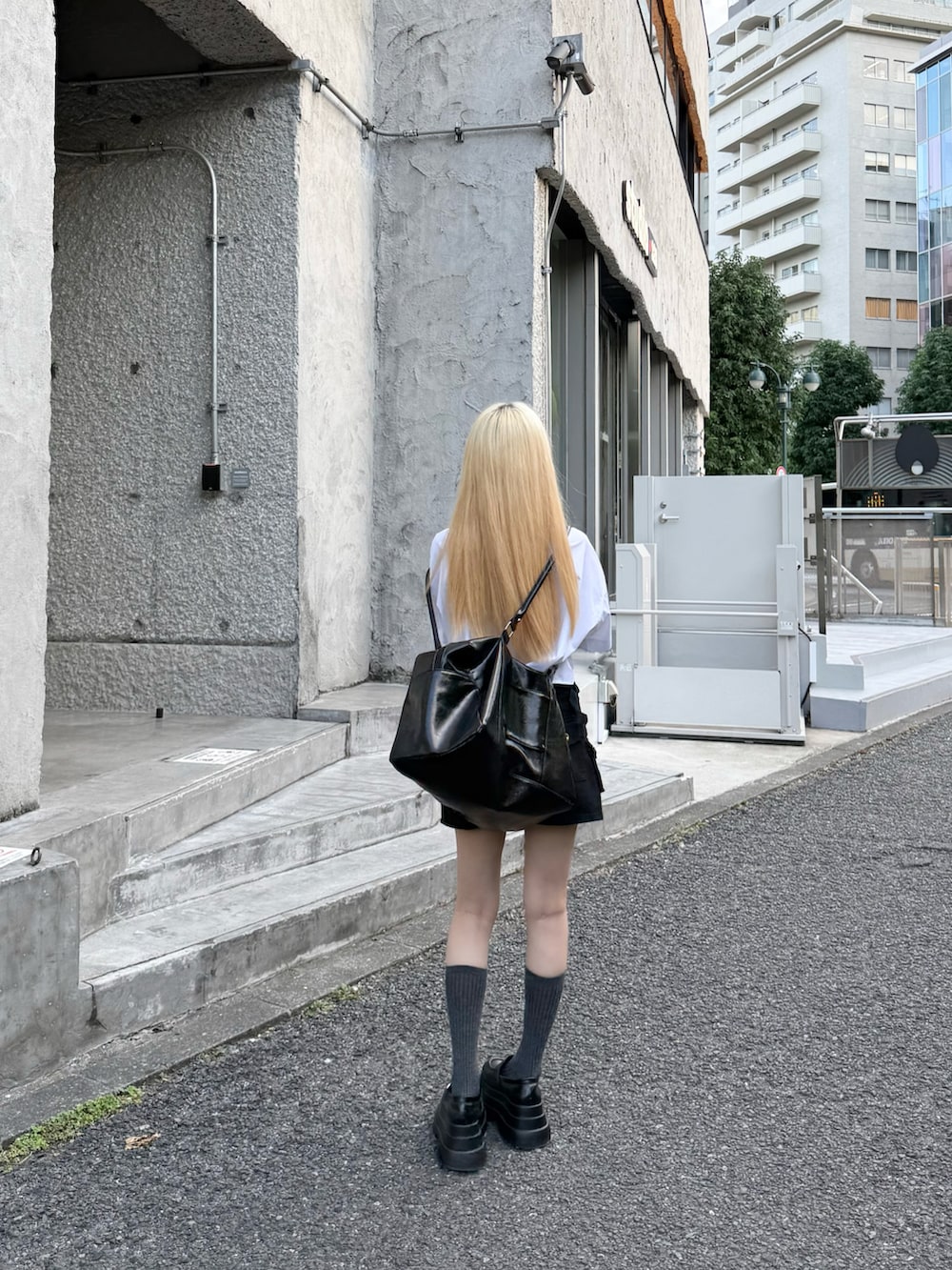 ホワイト系のシャツ/ブラウス、ブラック系のボストンバッグ、ブラック系のネクタイを着用したレディースの秋コーディネートの4枚目の写真