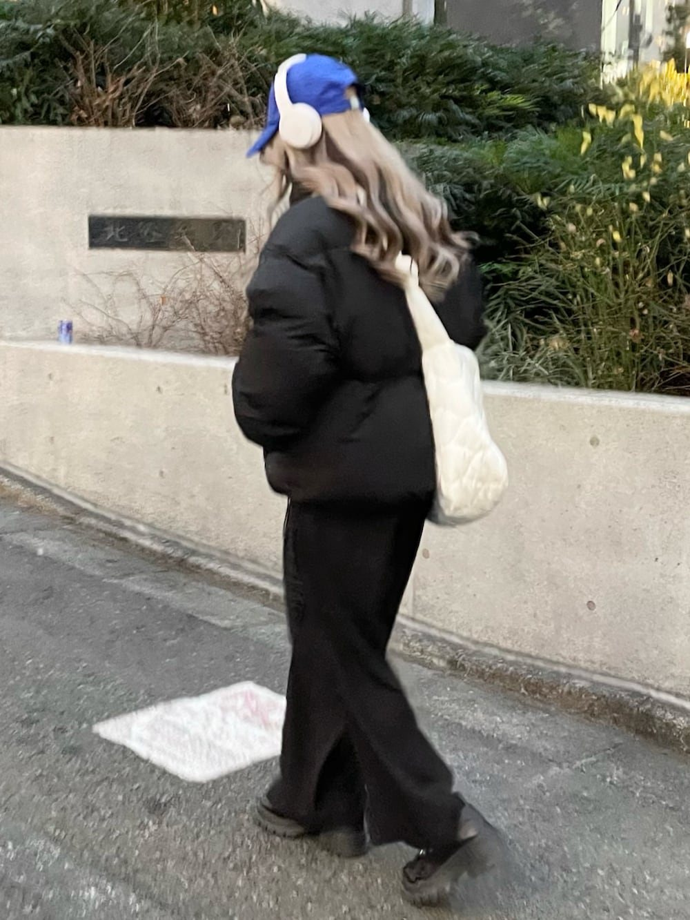 ブラック系のダウンジャケット/コート、ホワイト系のショルダーバッグ、ブラック系のその他パンツを着用したレディースの冬コーディネートの2枚目の写真